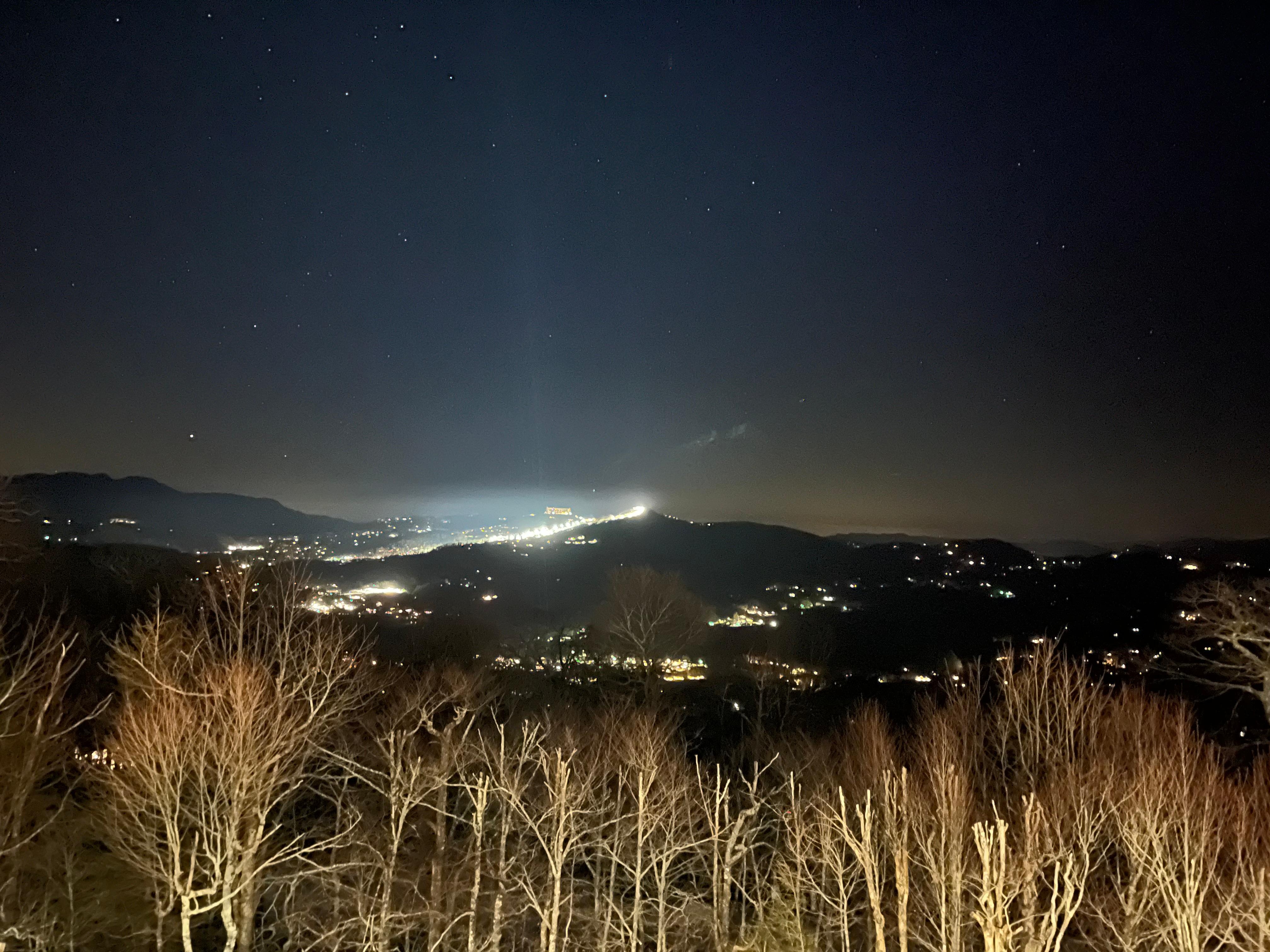 Nighttime view of Sugar Mnt with night skiing and snow blowing from chalet porch