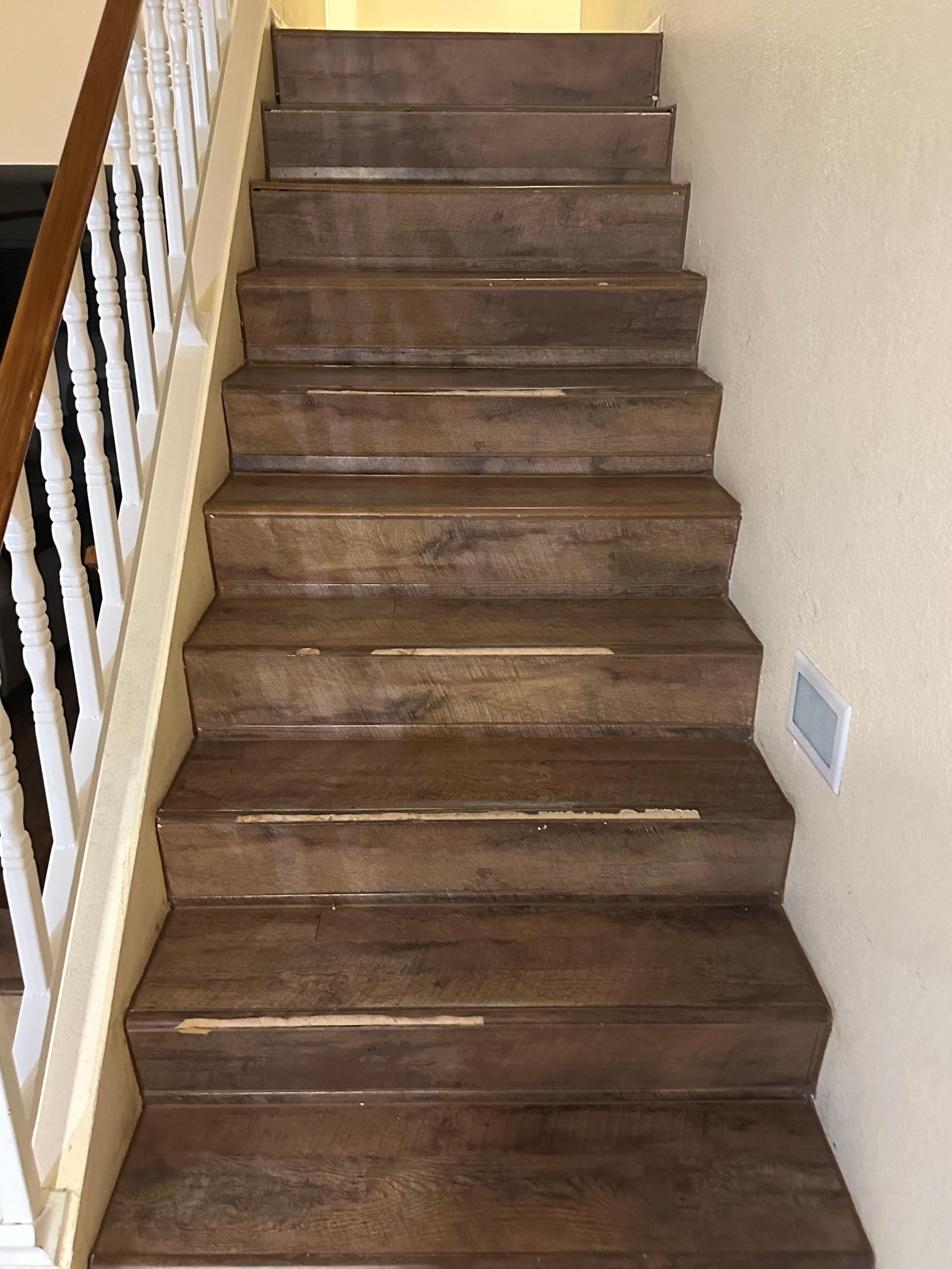 Stairs falling apart. Broken pieces stored on top of refrigerator.