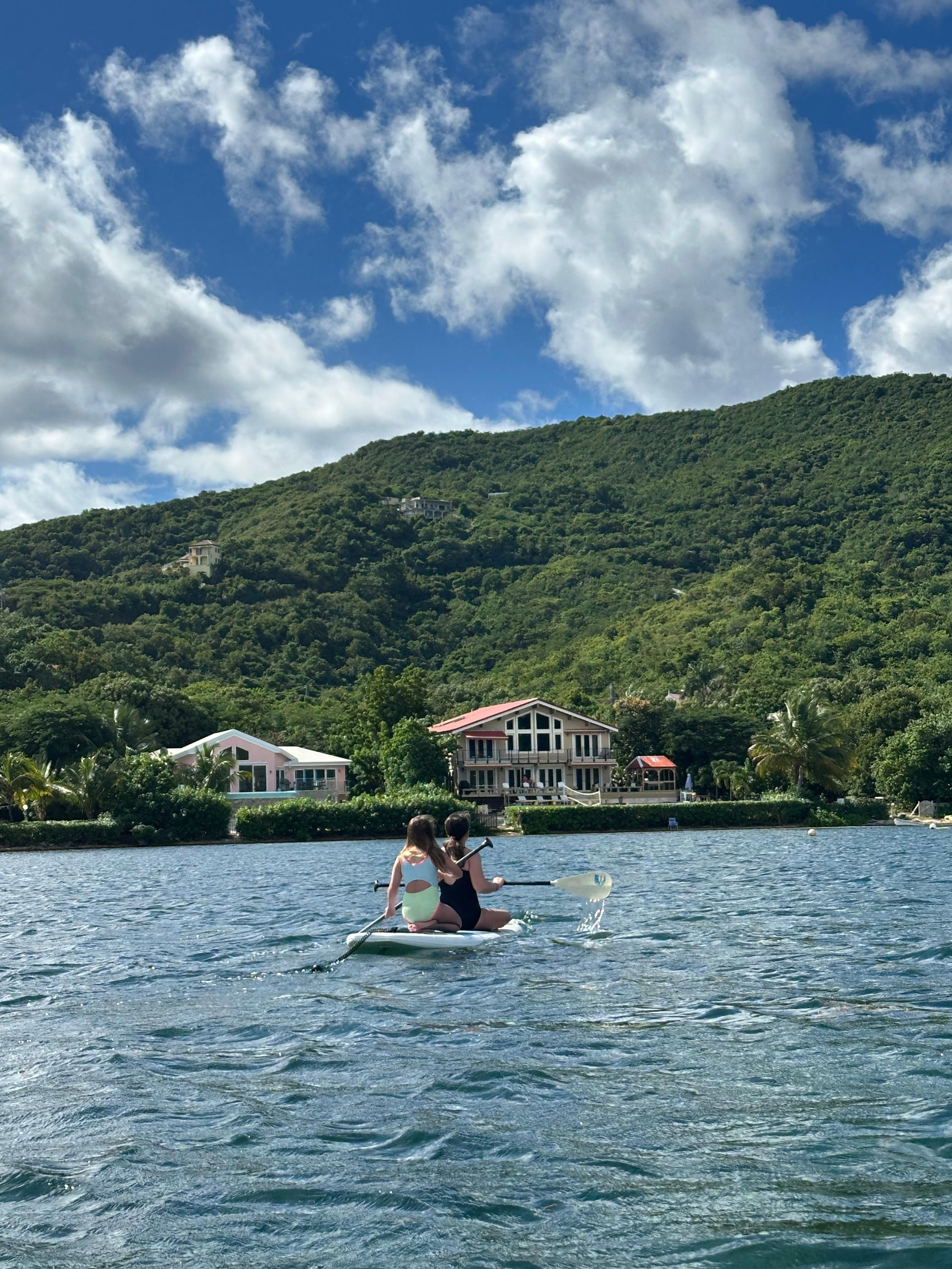 The girls paddle boarding back to the house. 