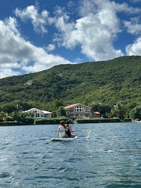 The girls paddle boarding back to the house.