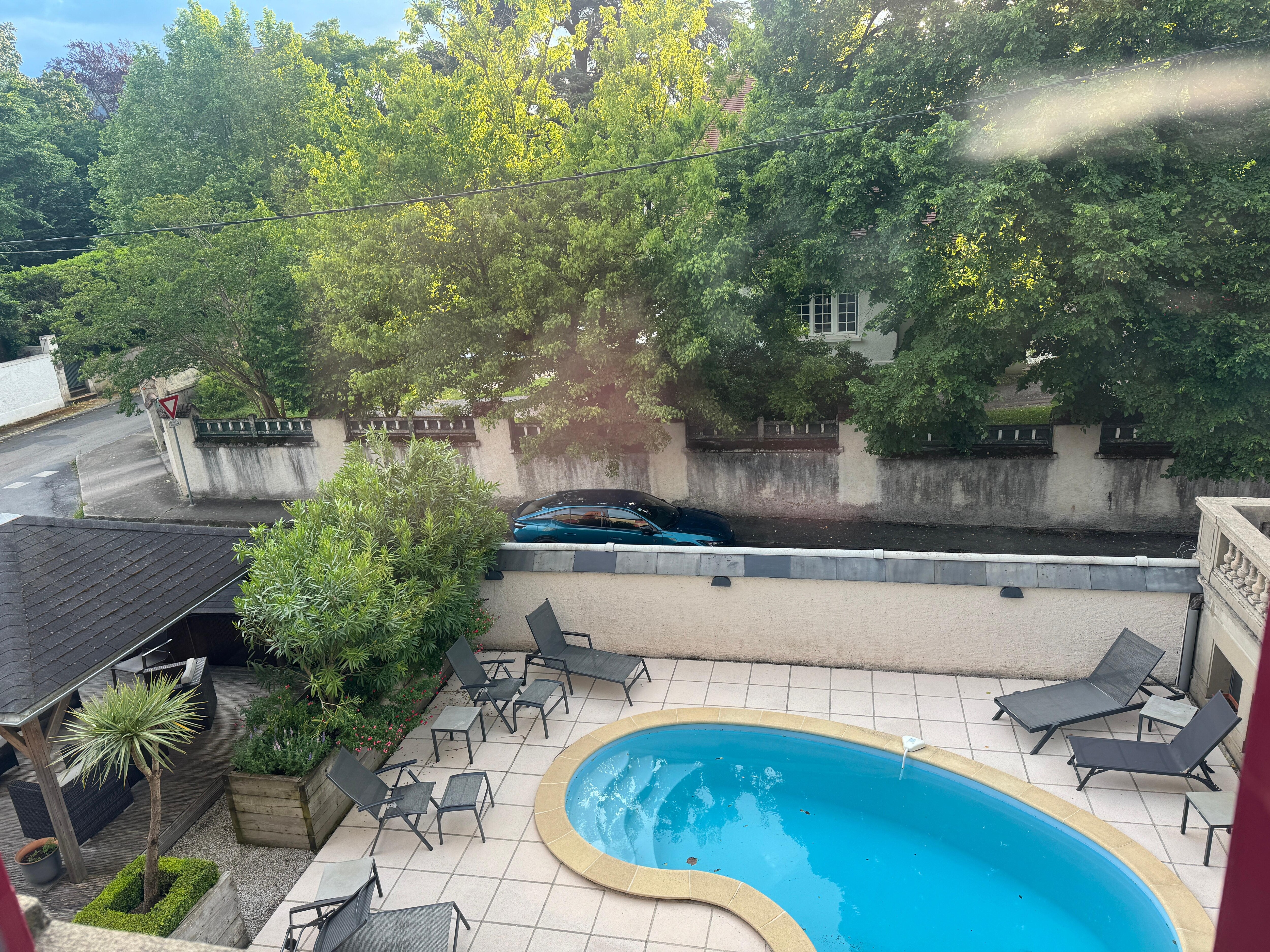 View from our room of the pool and side yard. In street parking just outside the wall 
