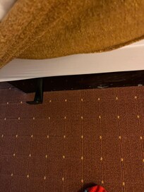 Metal brackets that are covered by the gold skirt.