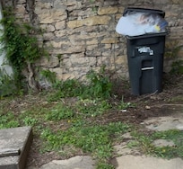 The over flowing trash can when we arrived, in the front yard.