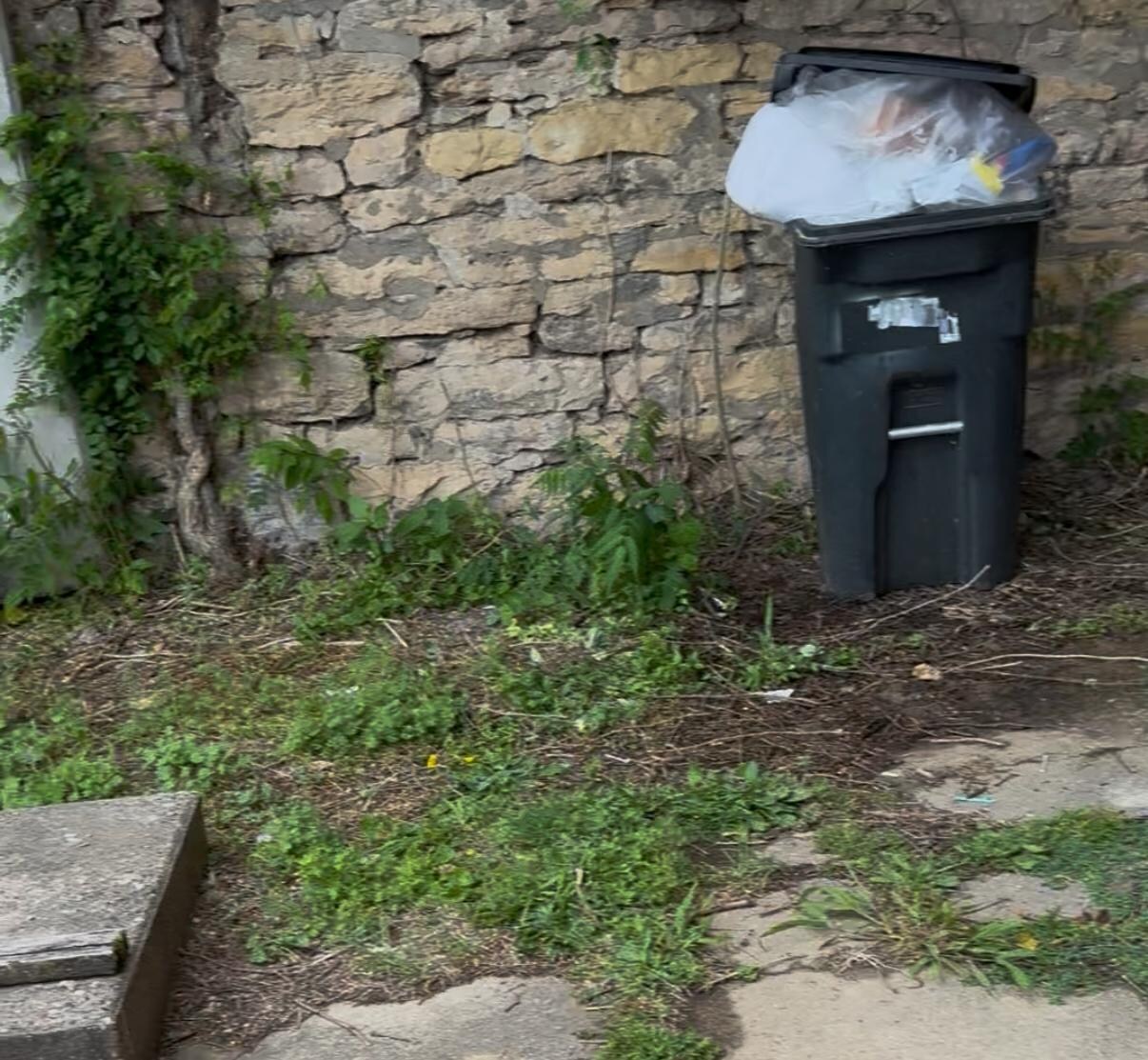 The over flowing trash can when we arrived, in the front yard. 