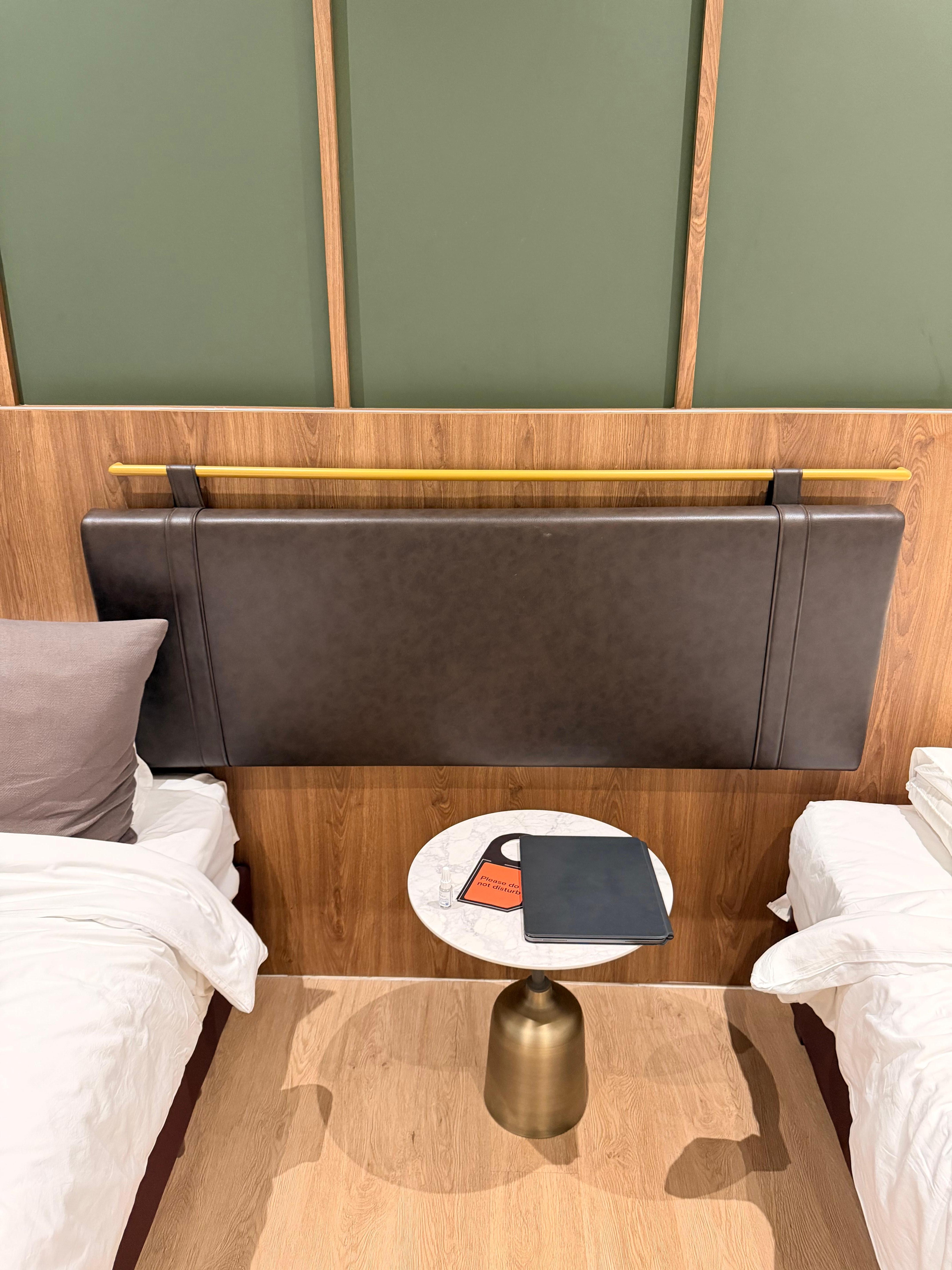 The headboard is positioned in the middle, so there is no headboard behind the pillows.