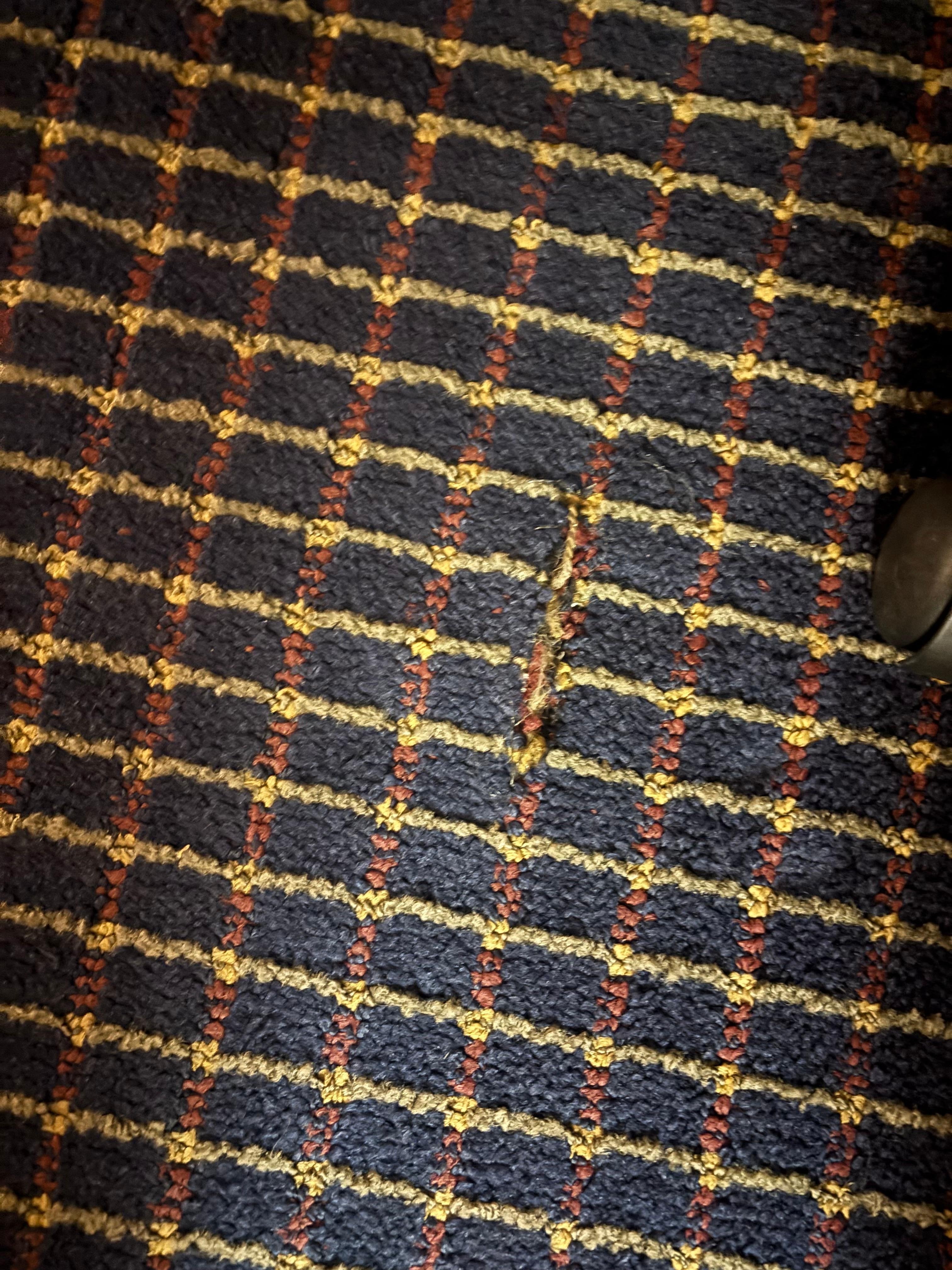 Small tare or seam opening in carpet, possibly from desk chair rollers