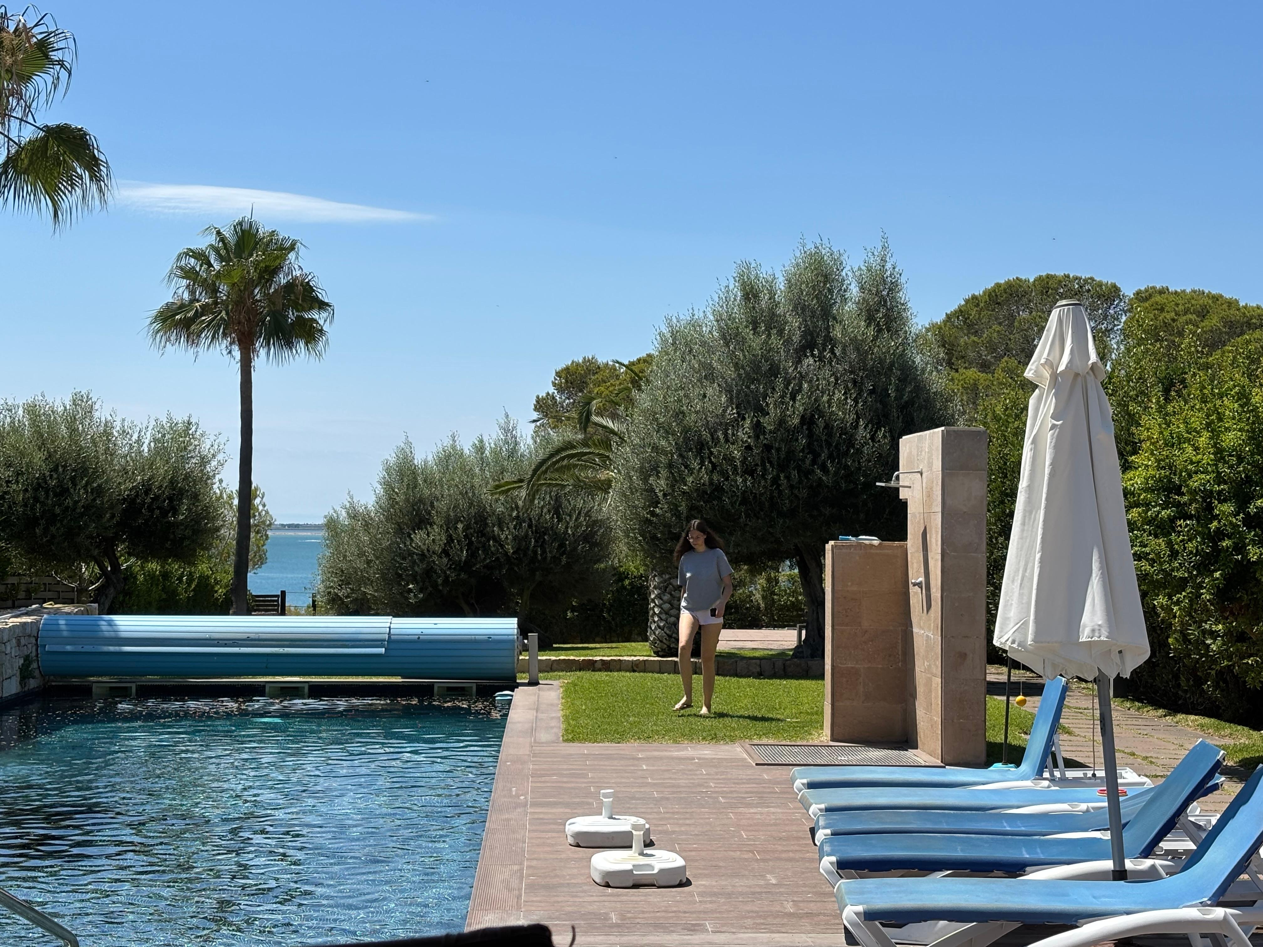 Achteraan is er eeen tuinhekken en daarachter ligt de zee.