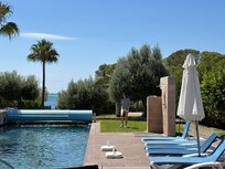 Achteraan is er eeen tuinhekken en daarachter ligt de zee.