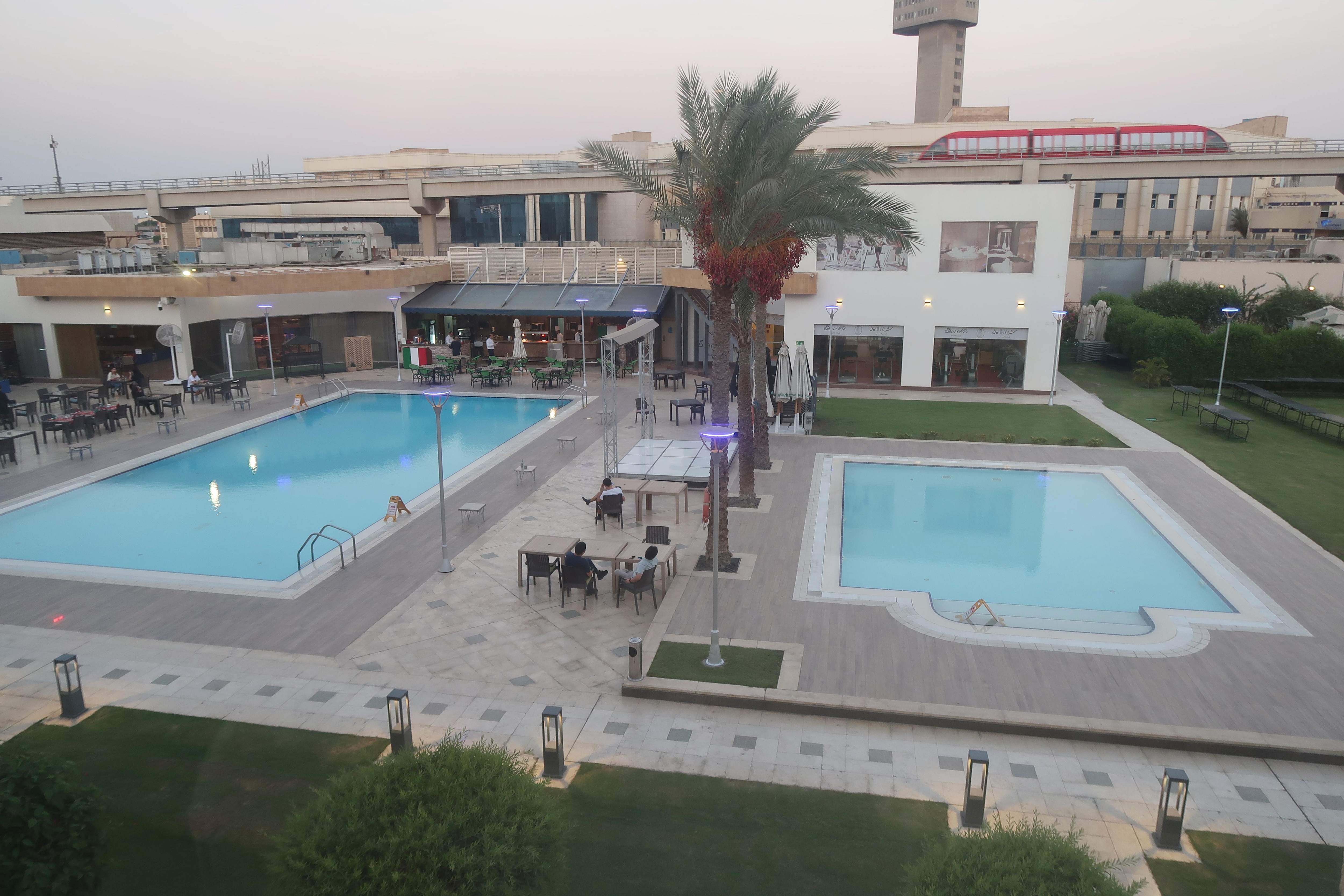 部屋から見えた　敷地内のプール。背後には空港ターミナルを結ぶＡＰＭ（無人全自動車両）が走っているのが見える。