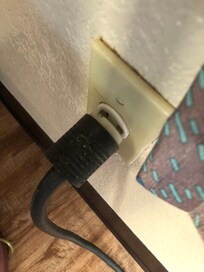 Main power cord for in-room air conditioning hangs loose in the socket, The window curtain brushes against it