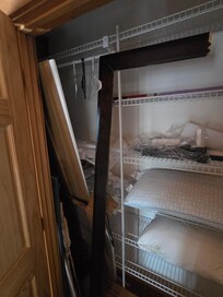 Garbage and broken bed pieces filling a closet