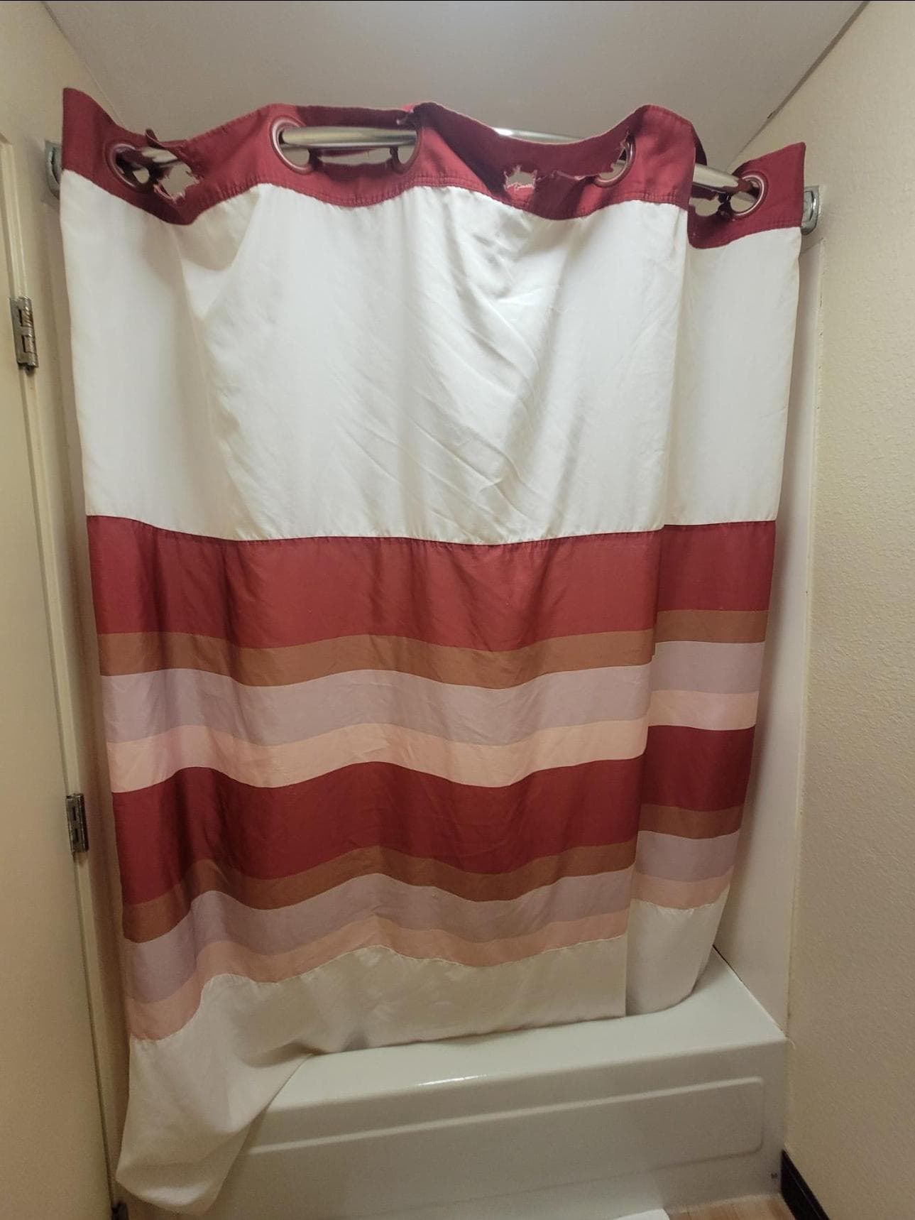 Shower curtain, torn where attaches to curtain rod