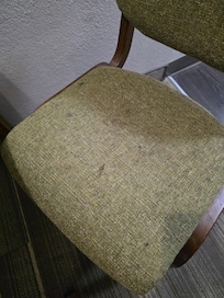 Filthy stained chairs at table.