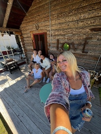Group photo in front of log cabin with our amazing host!