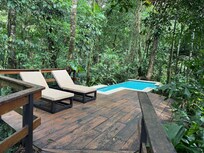 Villa private heated pool with river and small waterfall behind it.