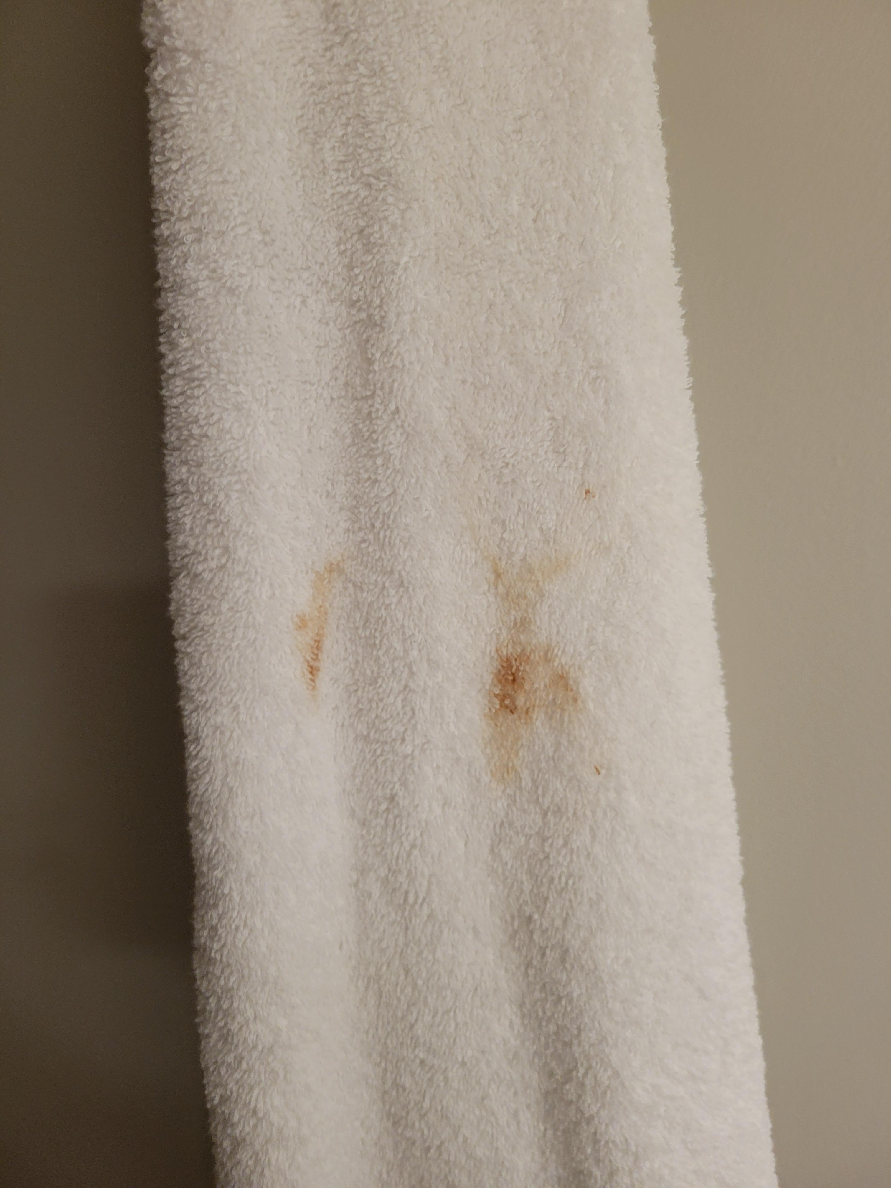 Stained towel in rack of clean towels