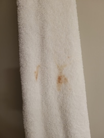 Stained towel in rack of clean towels