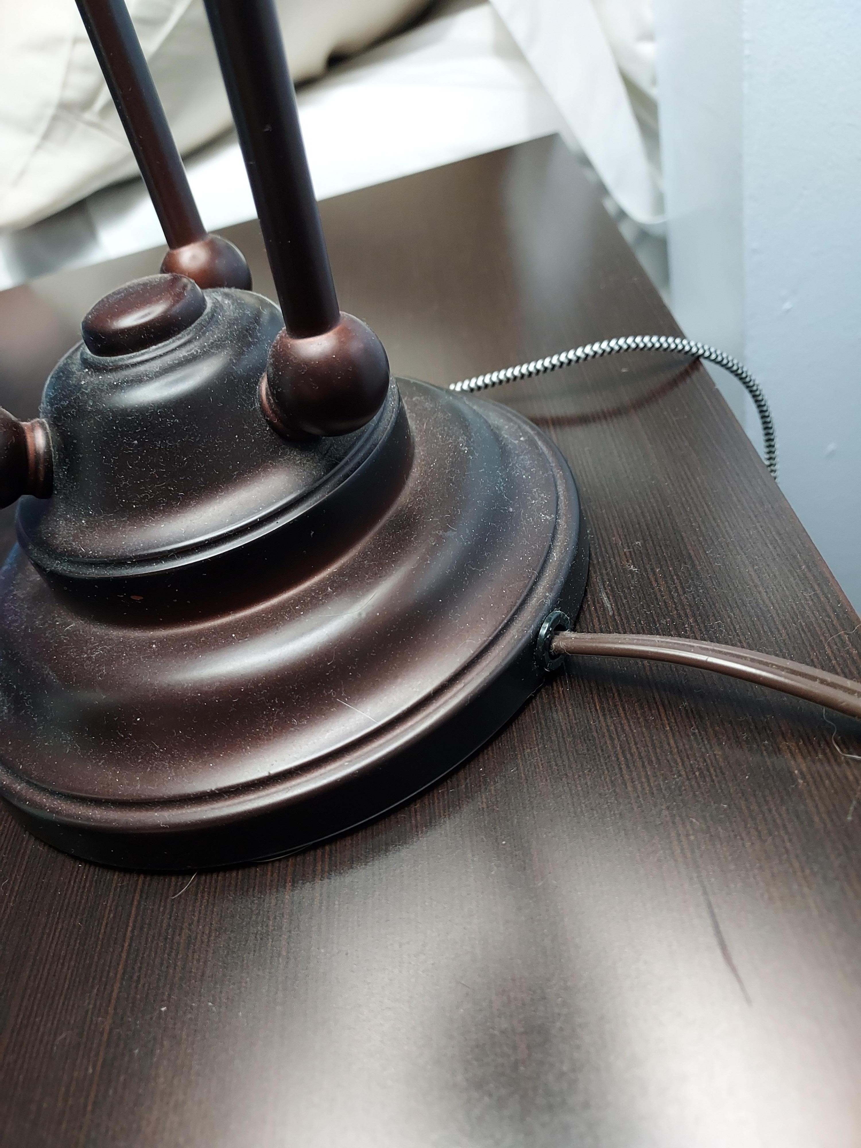 Dust and pet hair(?) on bedside lamp and table