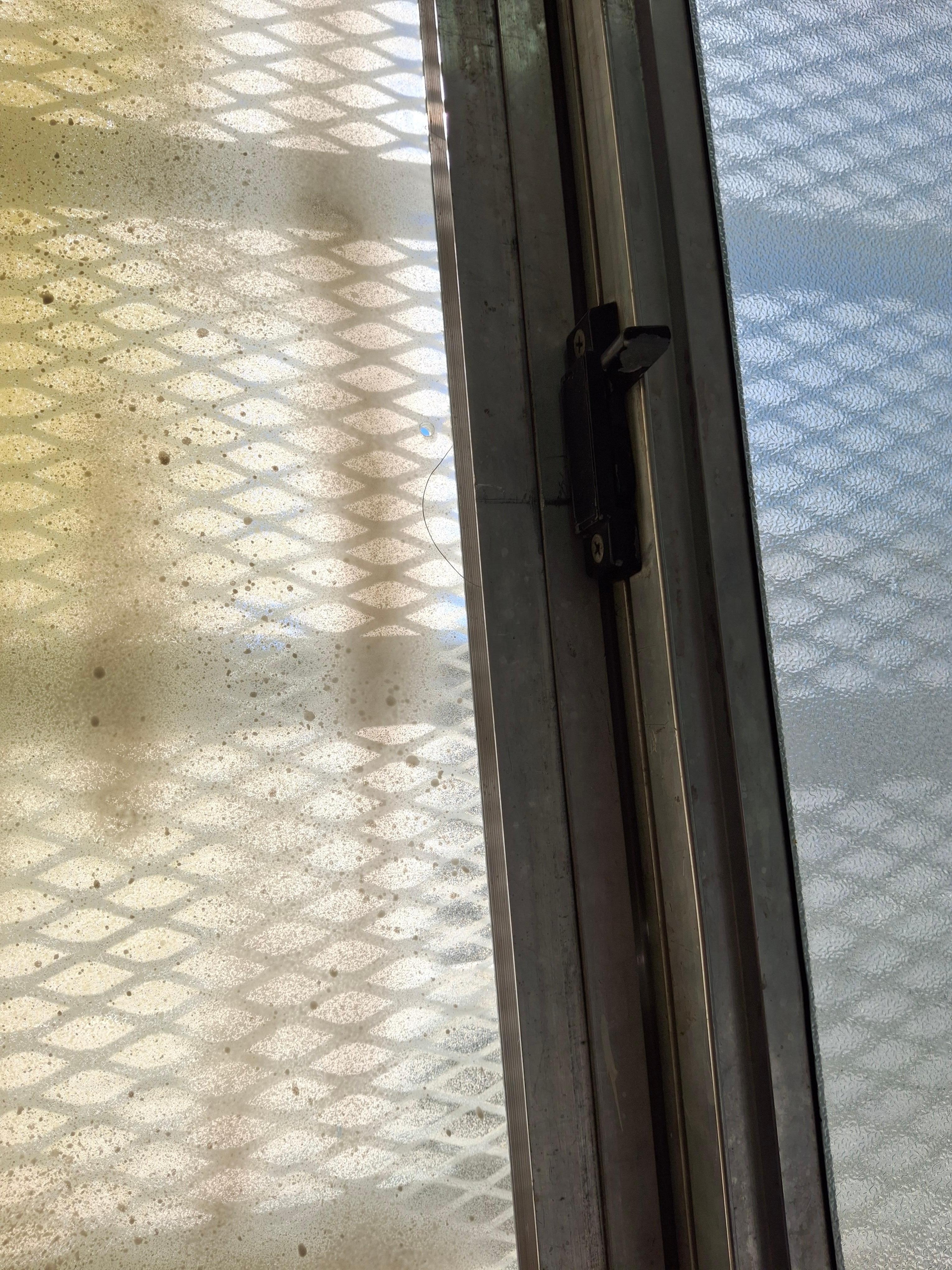 Hair stuck to window with filth