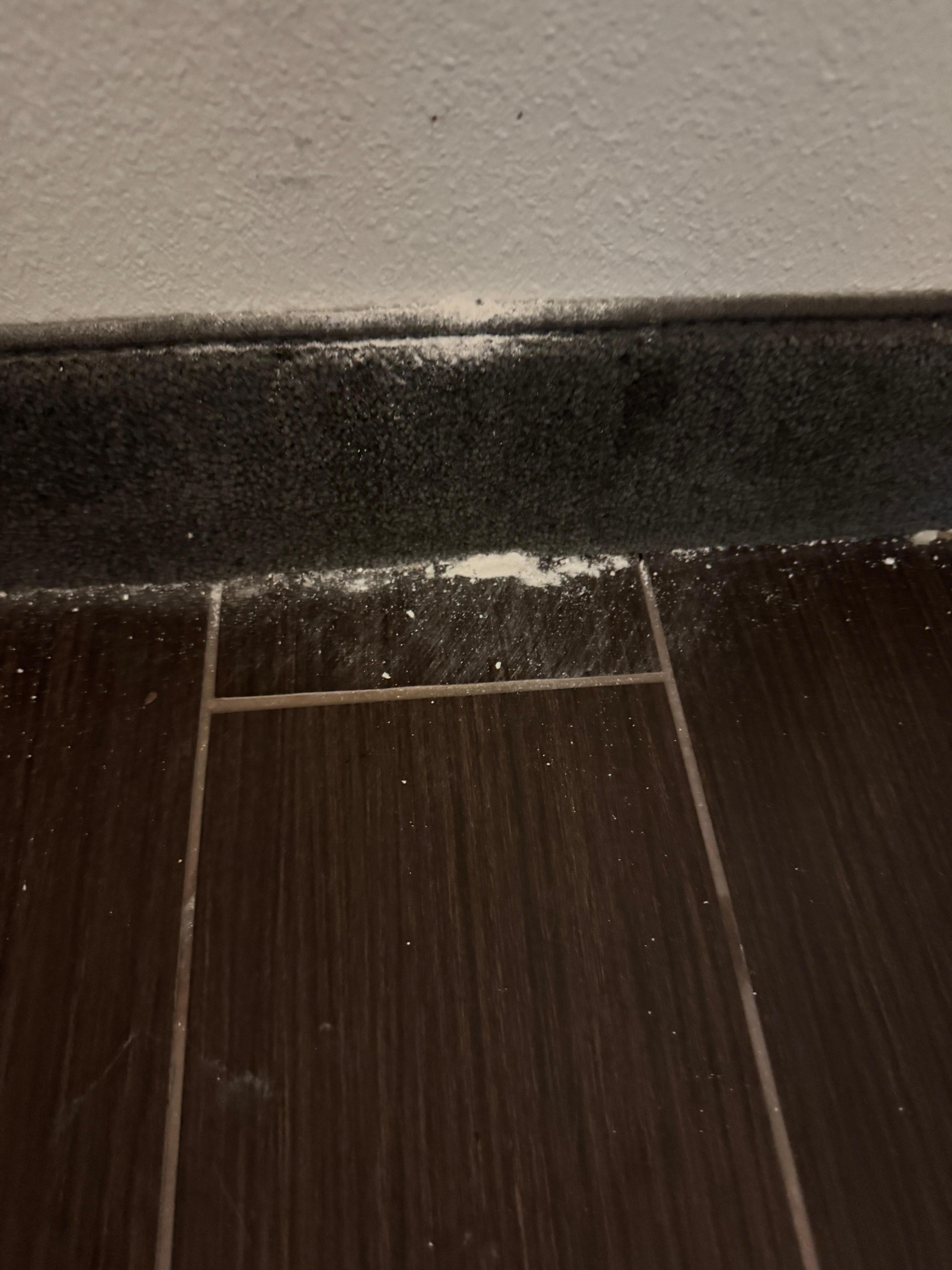 Drywall dust all over the floor by the entry. 