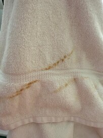Brown streak stains on bath towel that was rolled up and displayed on the bed (ready to use)
