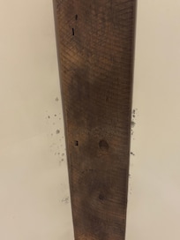 The substance visible on the wooden surface and adjacent wall appears to be mold