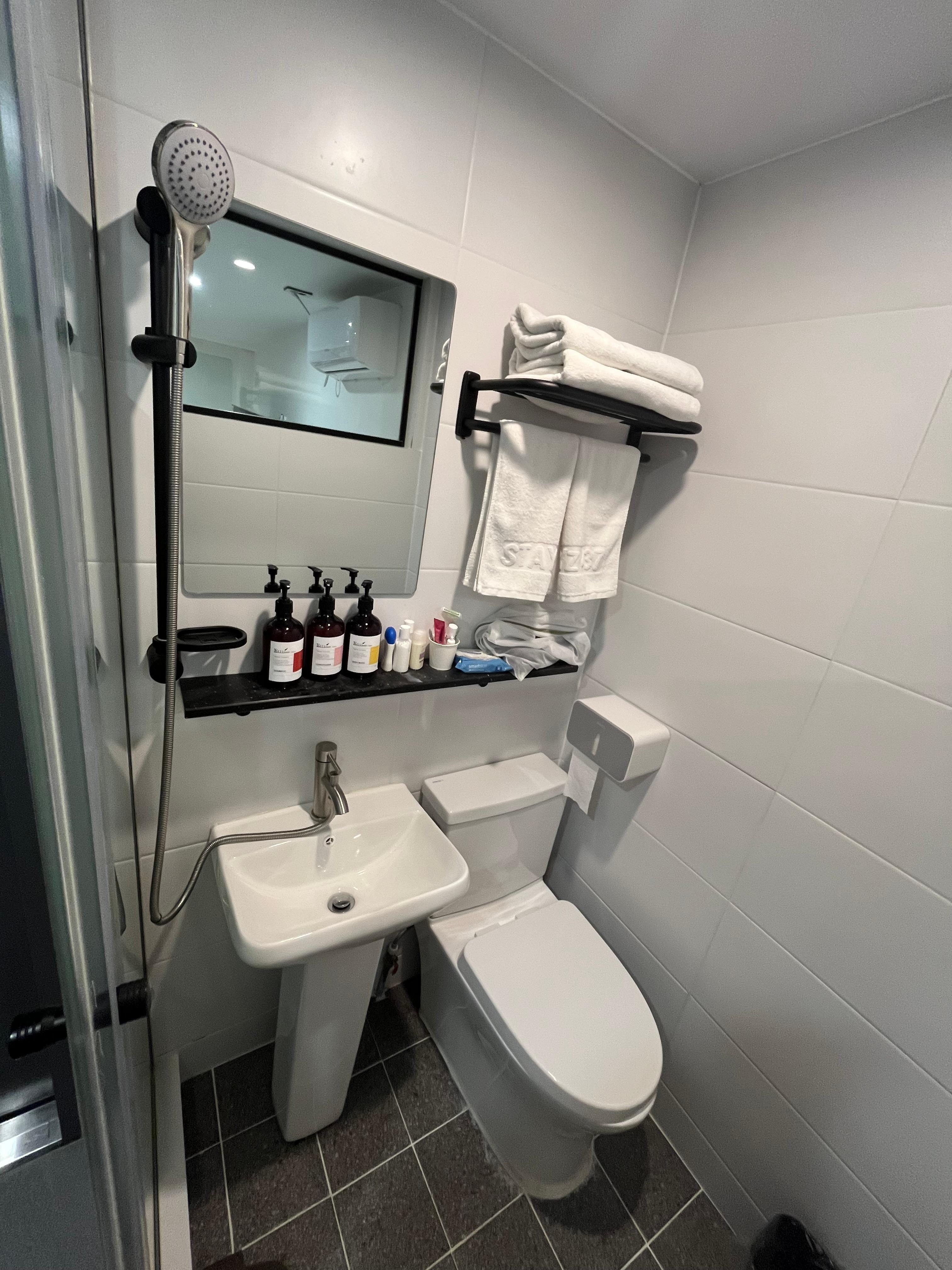 Wet room style. Shower head sits above the bathroom. When on the toilet and sink get wet so be sure to close the toilet lid, remove rubbish bin and toilet paper is within the holder. Also toilet paper access is slightly behind the toilet to reach it.