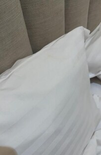 Tâches de couleur marron présent sur les 2 taies d'oreillers du lit