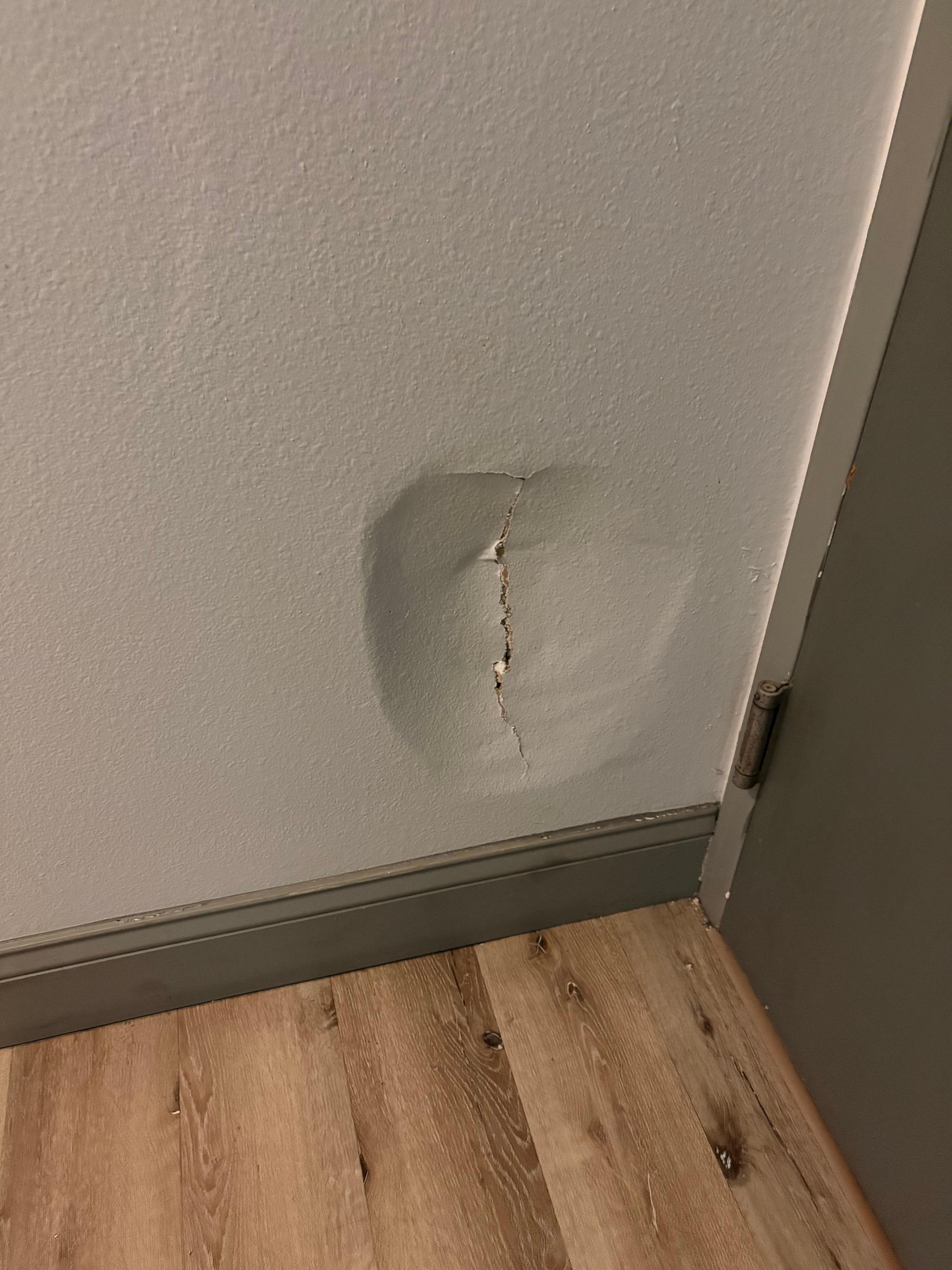 Hole kicked in wall of second room. One example of the condition of the hotel.