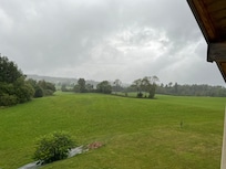 Vue de la fenêtre de l’appartement. Environnement calme et verdoyant.
