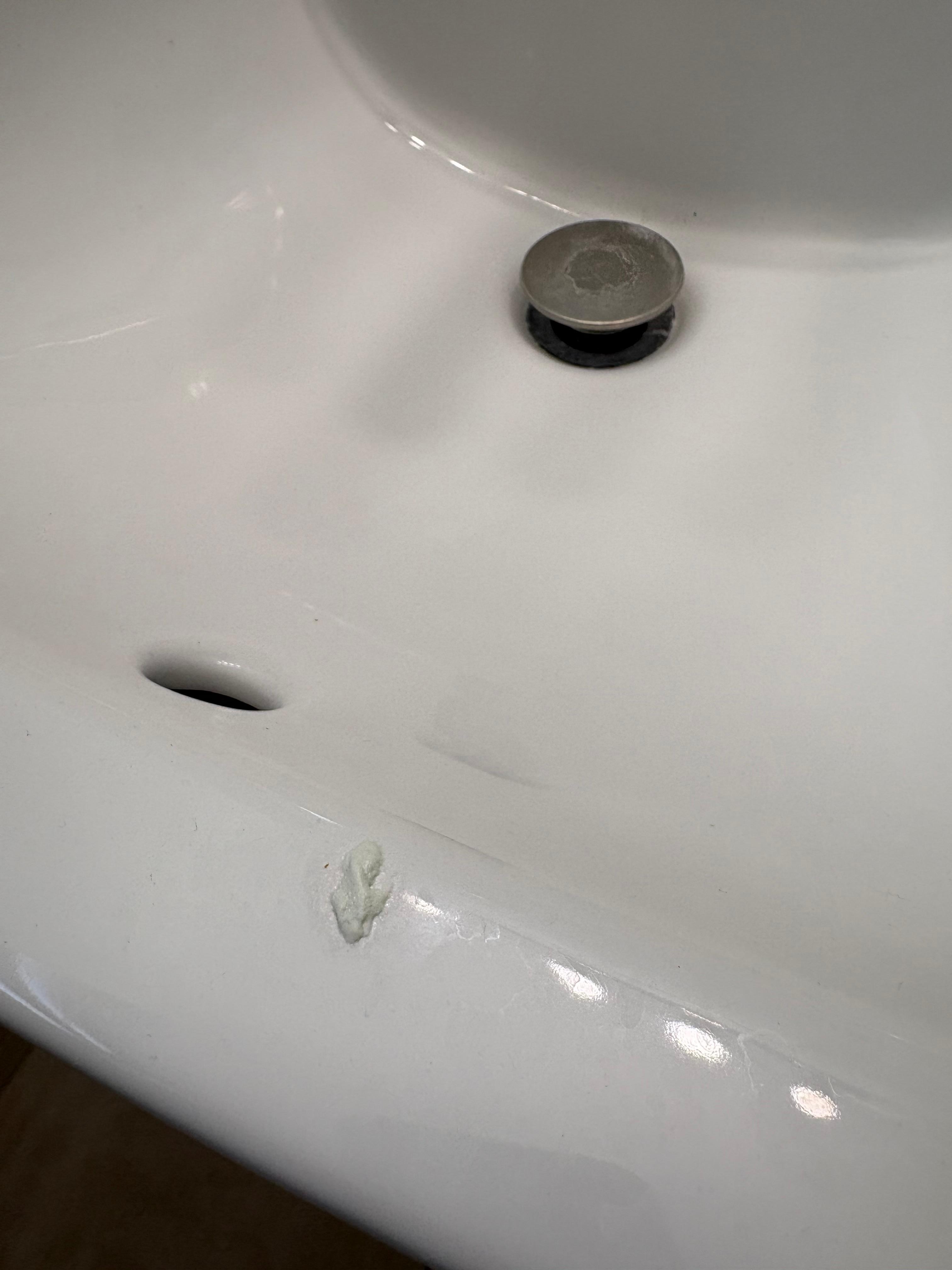 Glob of toothpaste on bathroom sink 