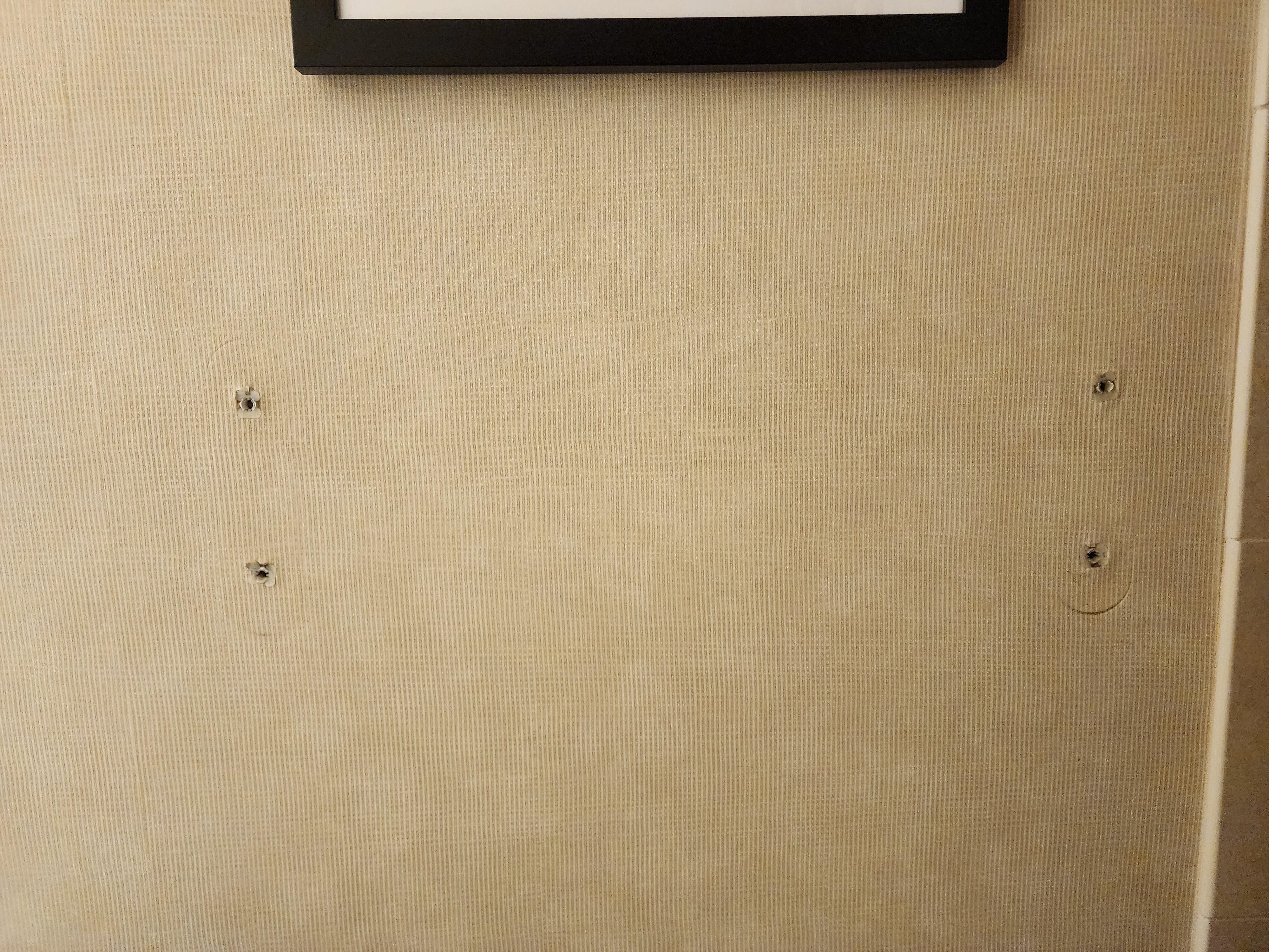 Bare holes left from the towel rack in the bathroom.