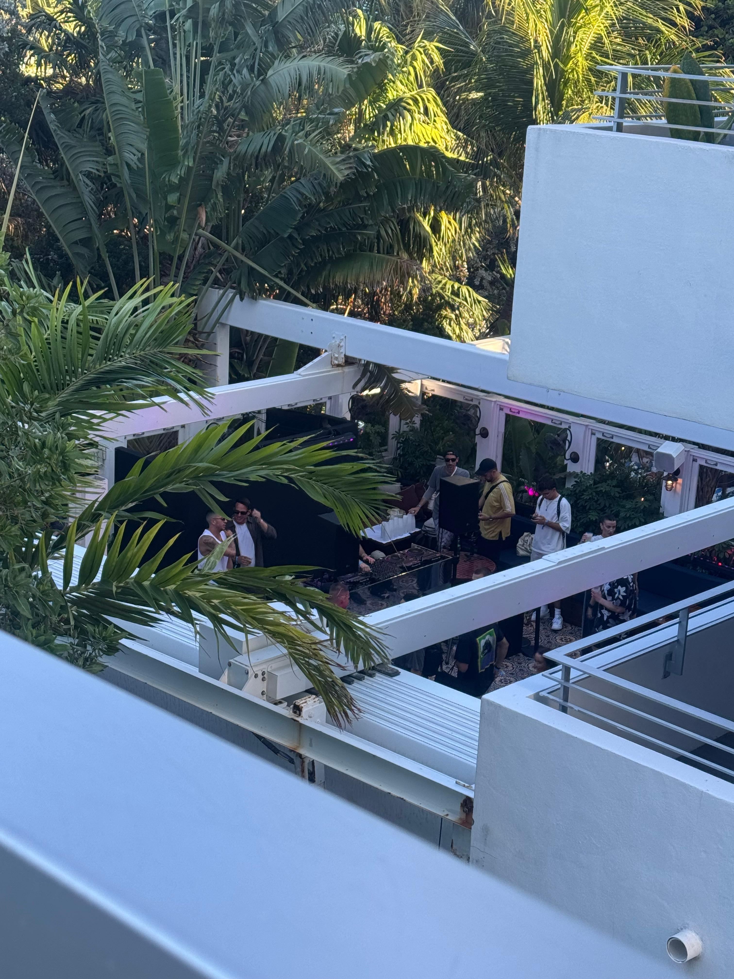 view from unit deck of bar/club in building next door with loud music