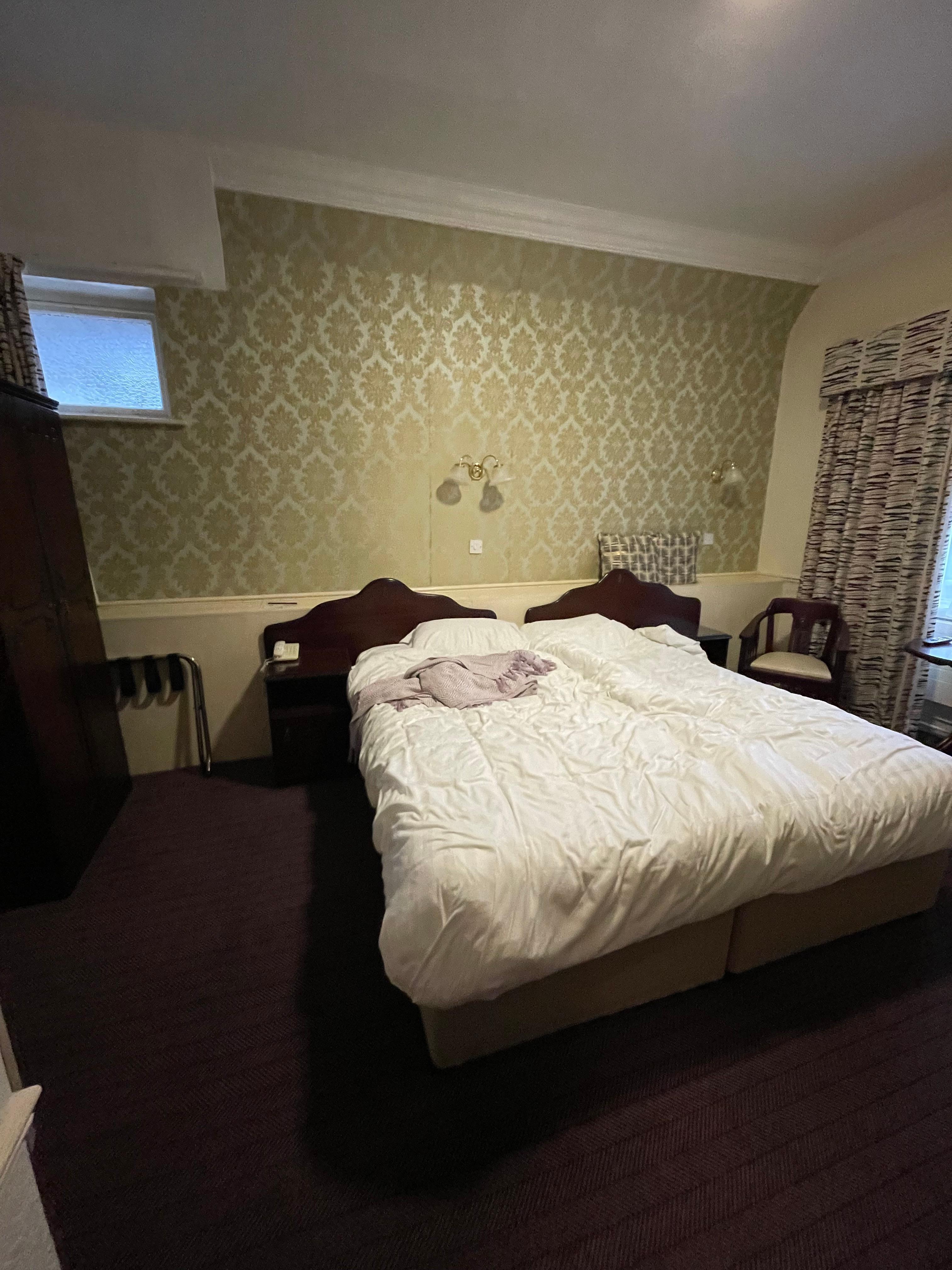 Room upon checkout, wooden wardrobe is to the left of the bed and the entry to the washroom is to the left of the wardrobe 