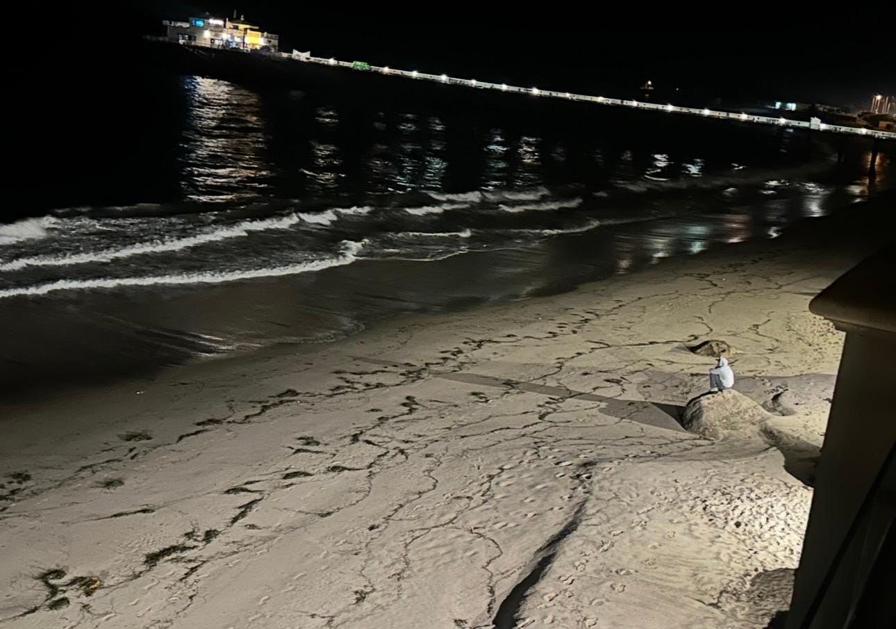 Stranger steps away from the hotel on the beach very late at night