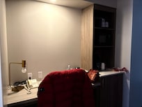 Desk area with coffee maker, microwave and mini fridge.