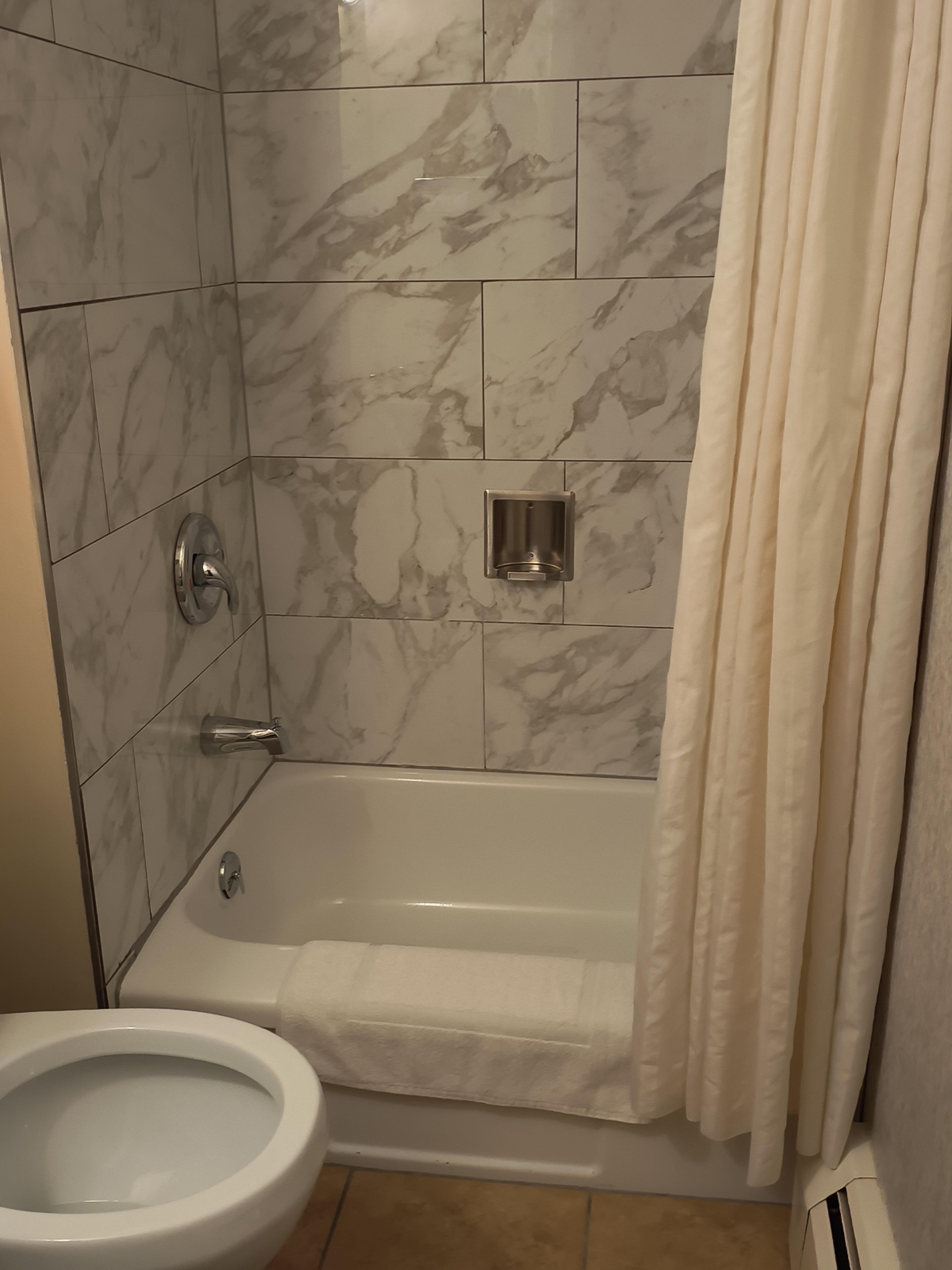 Shower with small tub that can be used for bathing children. The tub is about 30" long and about 10" deep.