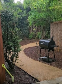 Pretty yard. Covered porch had chairs. Fence is around hot tub.