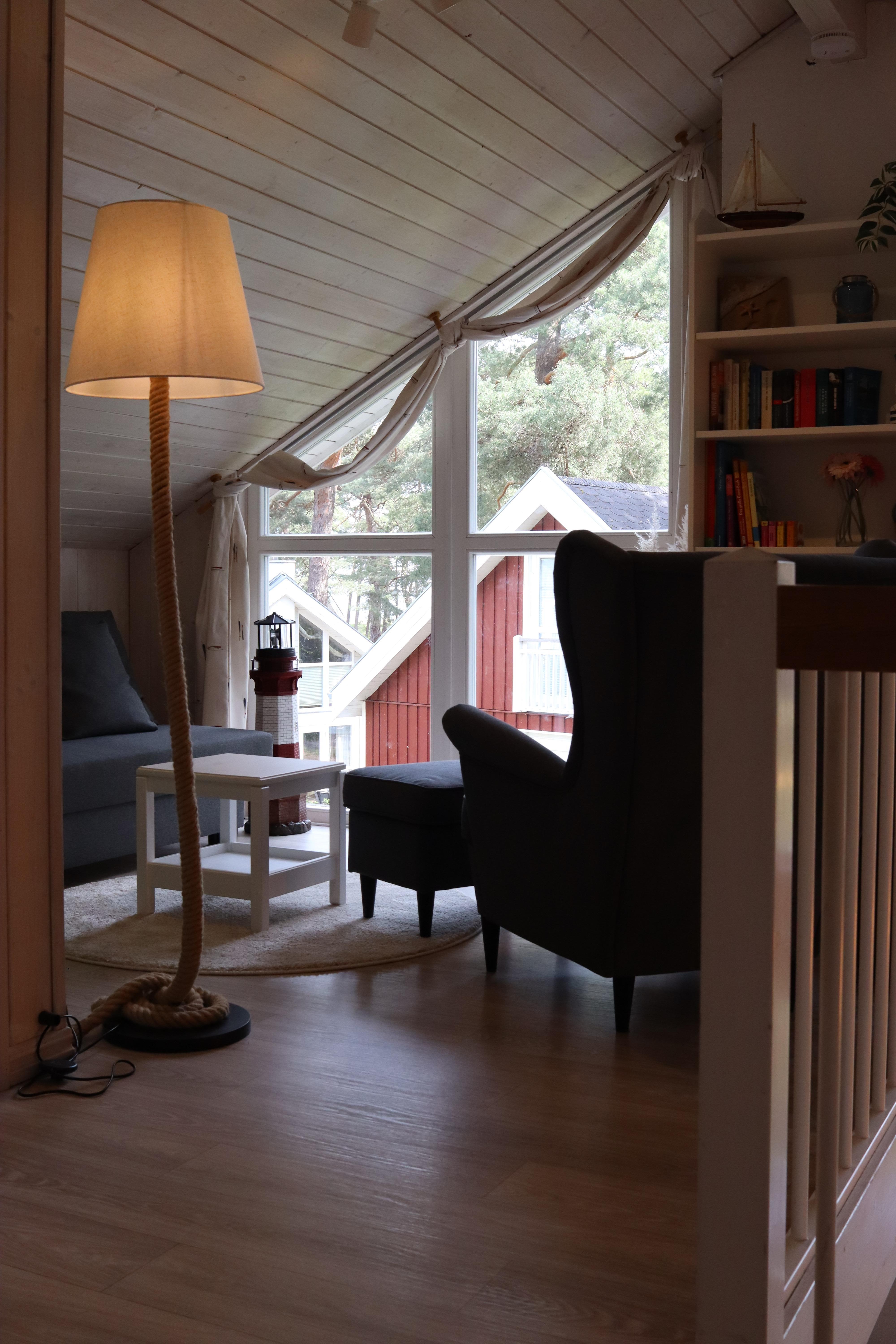 Galerie mit Sessel und kleinem Sofa mit Bücherregal