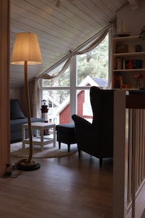 Galerie mit Sessel und kleinem Sofa mit Bücherregal