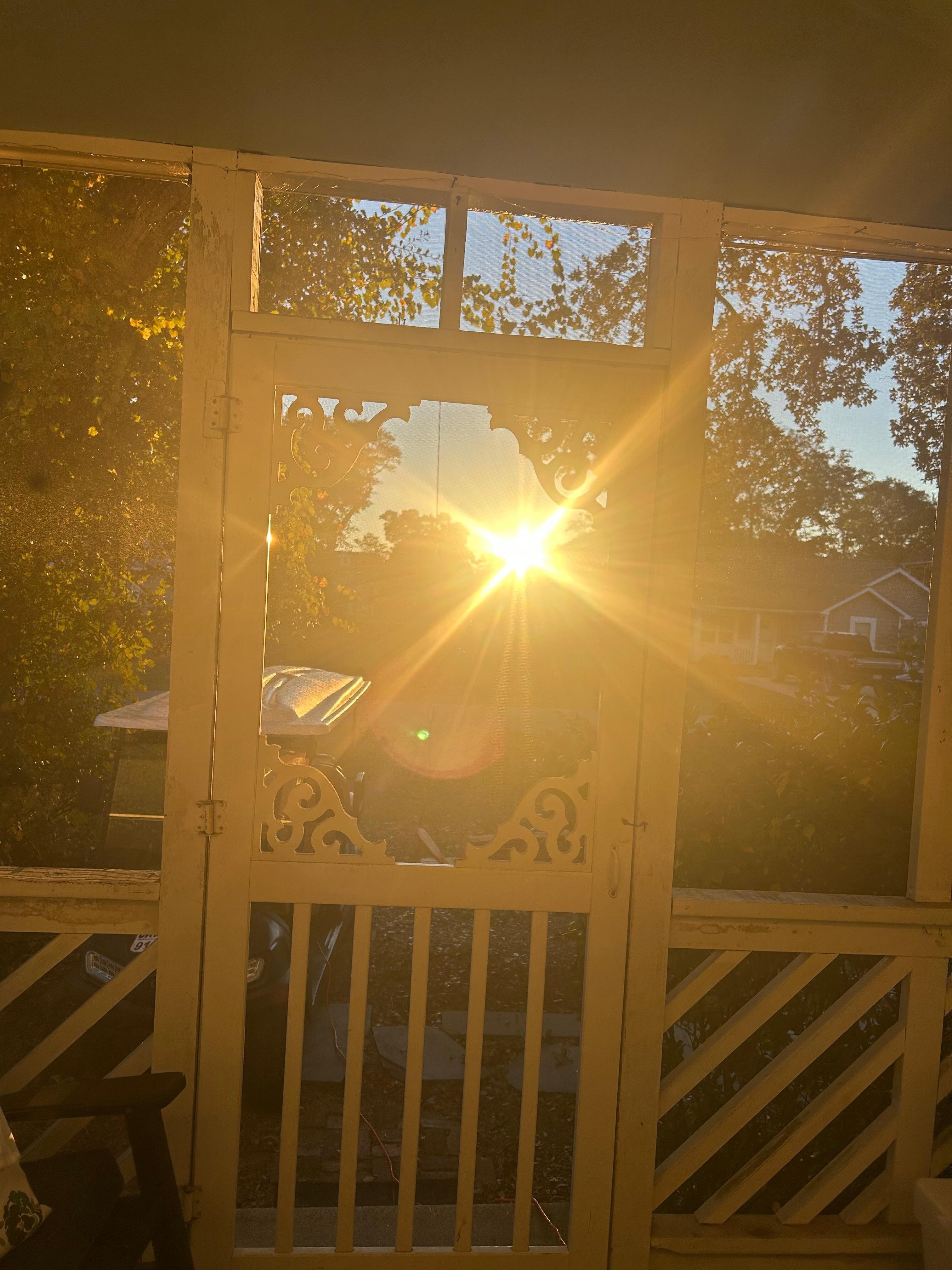 Morning sunrise looking out through the screened in porch while drinking our morning coffee sitting in the living room 