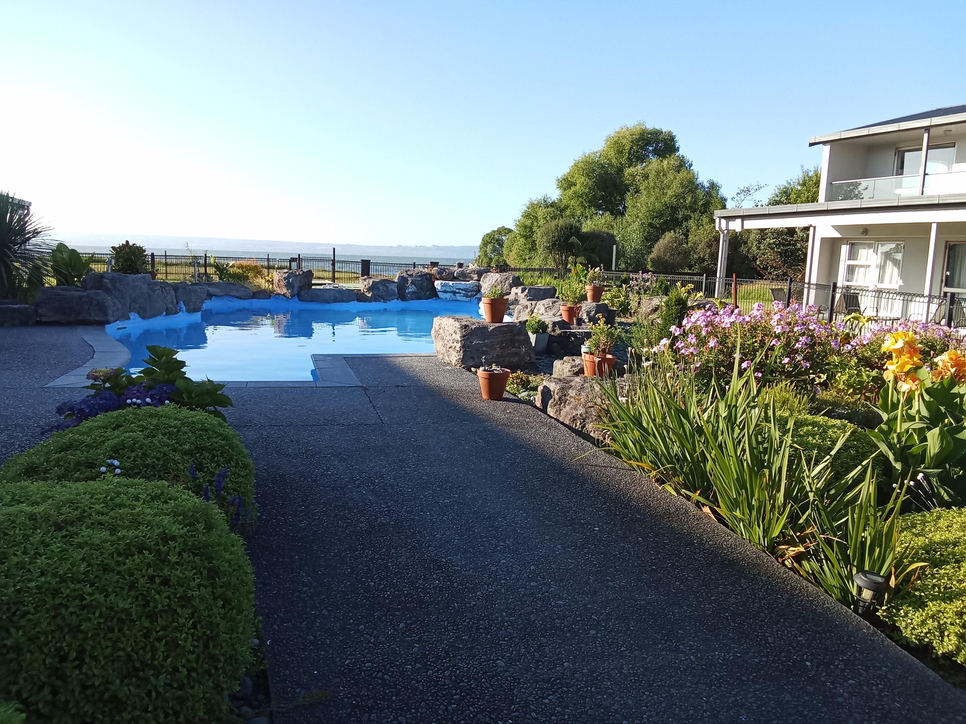 The lake is just beyond the property. Beautiful gardens and rockery surround the pool.