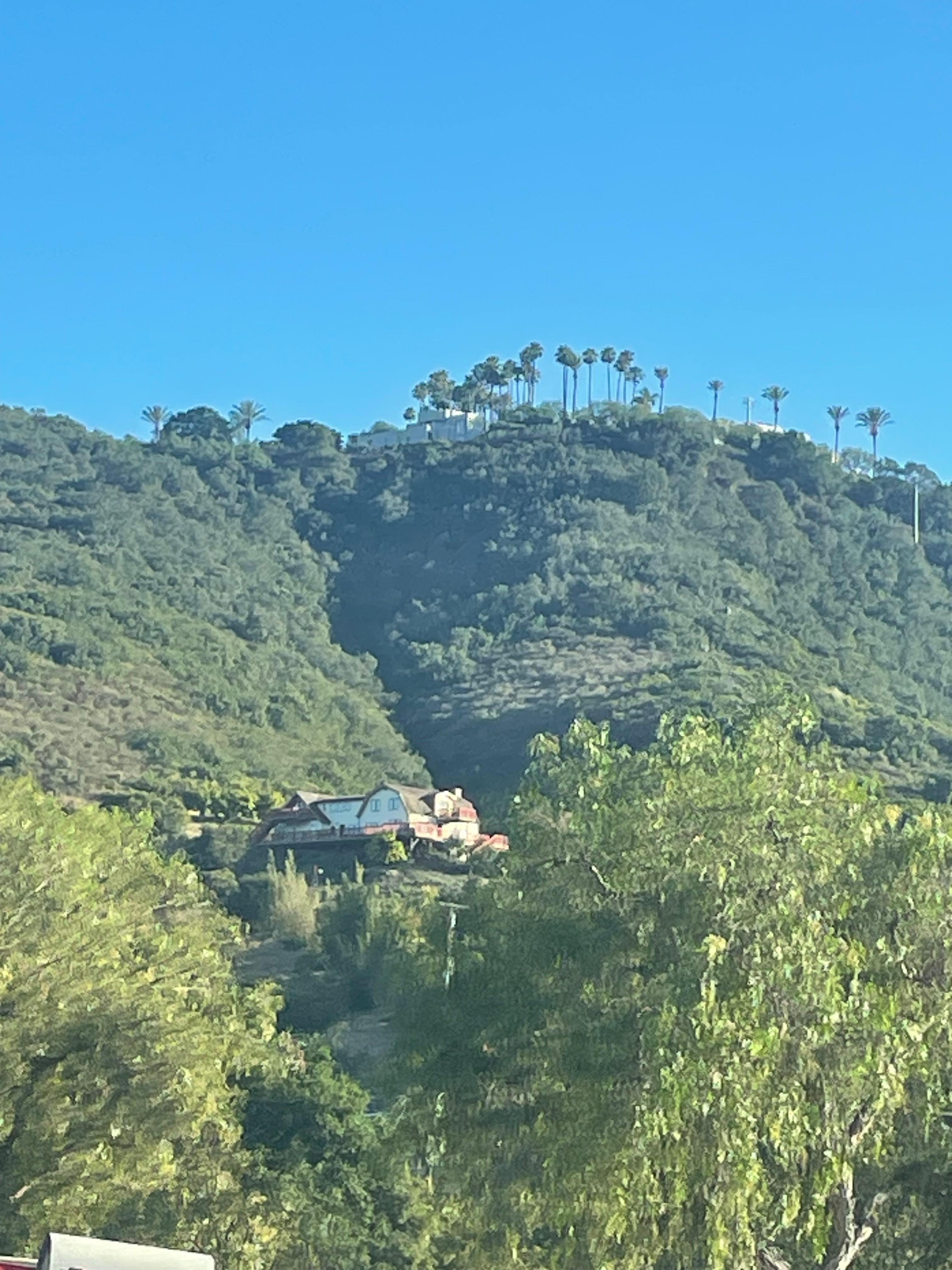 View of the house in the middle of the hill on the drive up. 