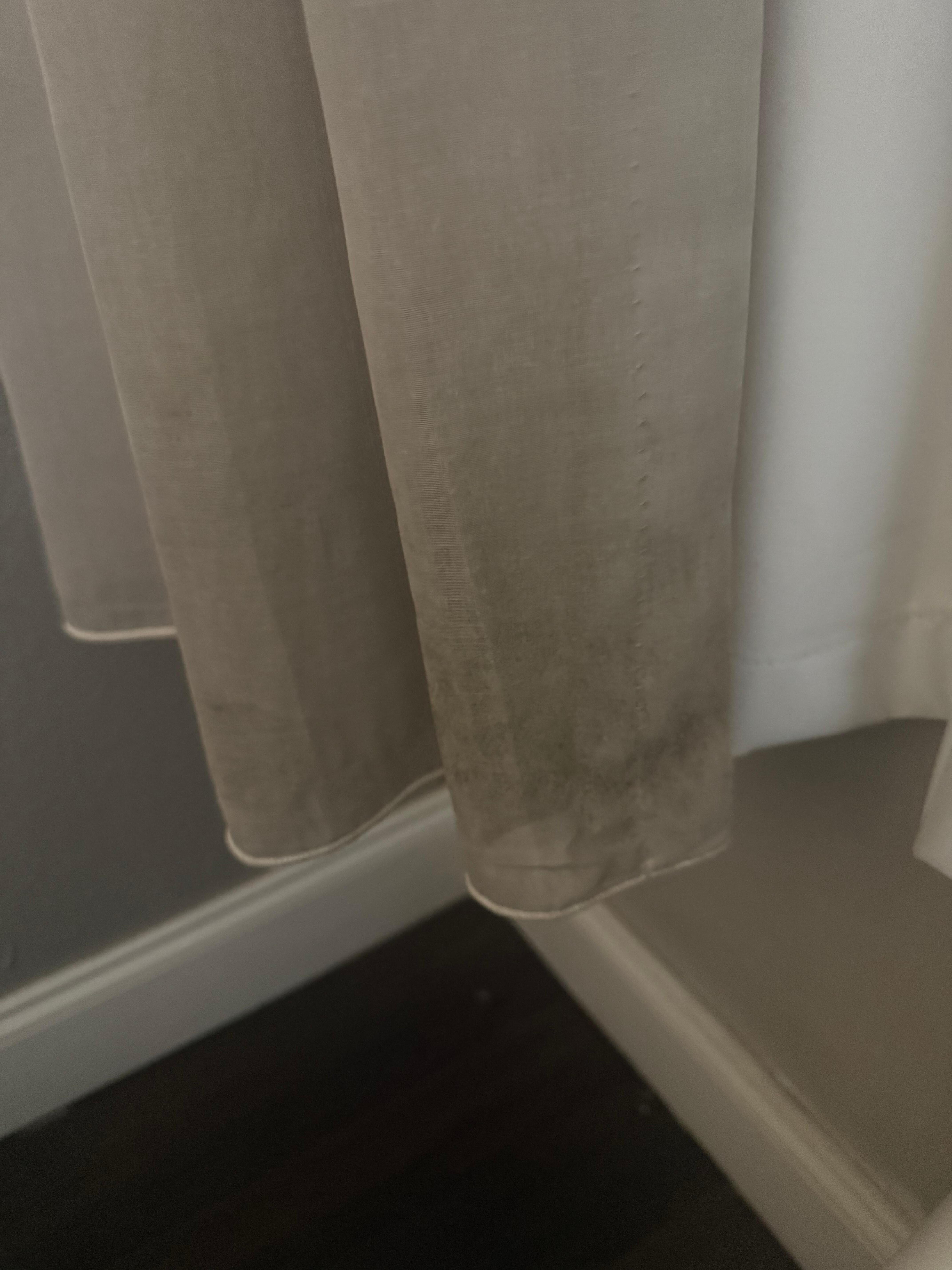 Bottom of curtains are black with dirty or mildew 