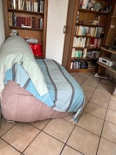 old love seat with dirty old blankets for cover