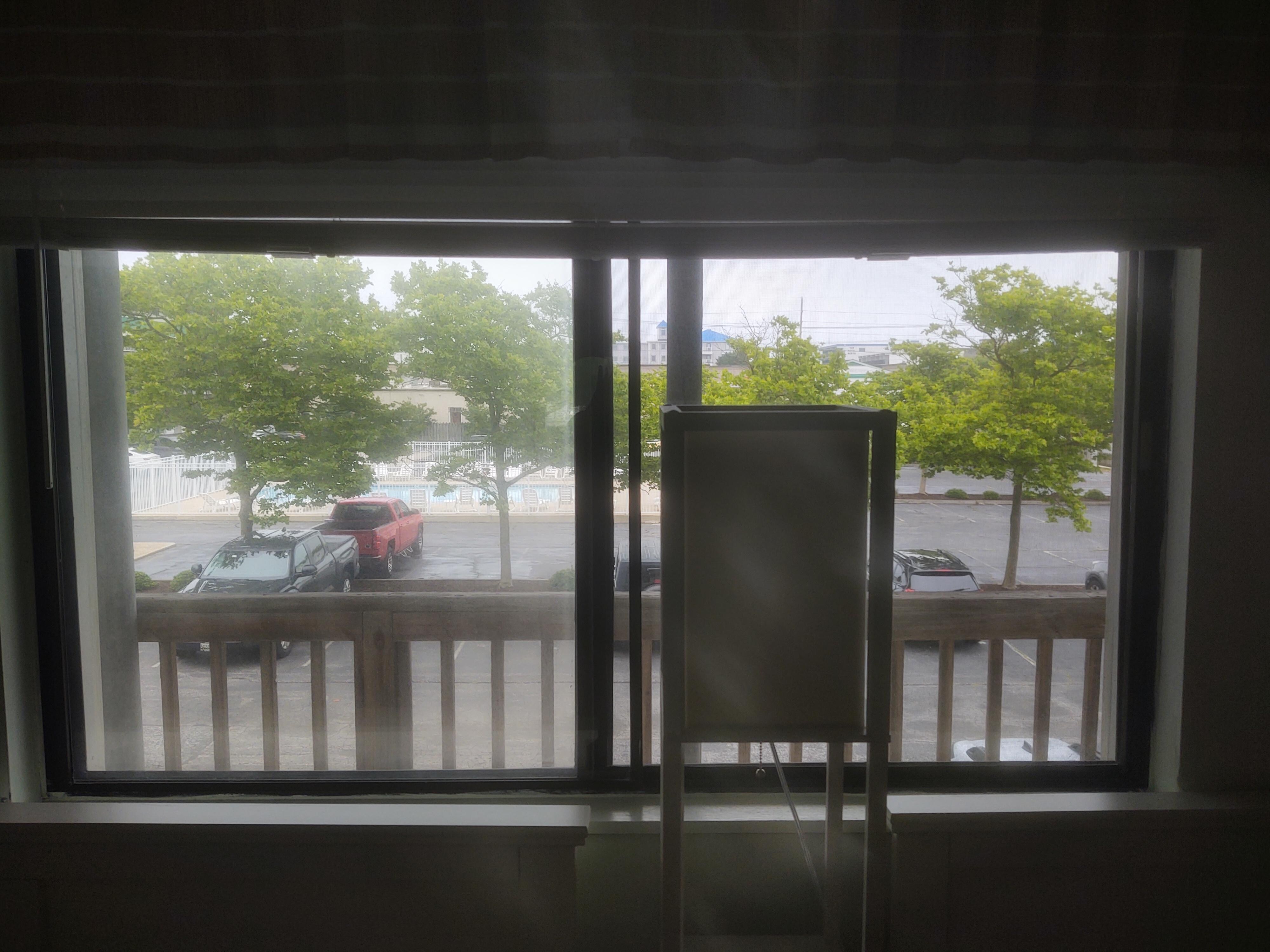 View of parking & pool from bedroom (only opened shade and blinds to take pic)