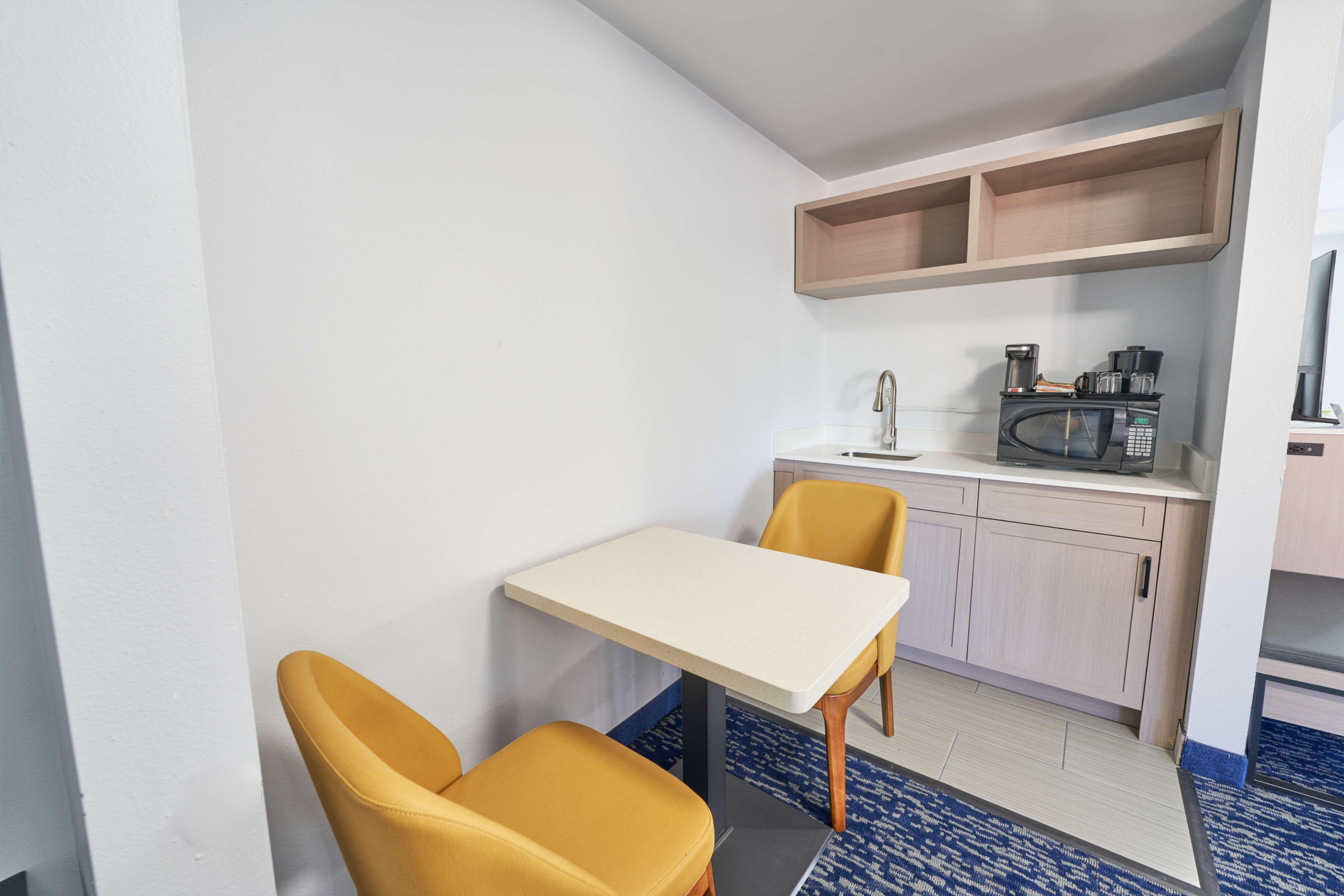 Kitchenette area in the room with dining seats and table space