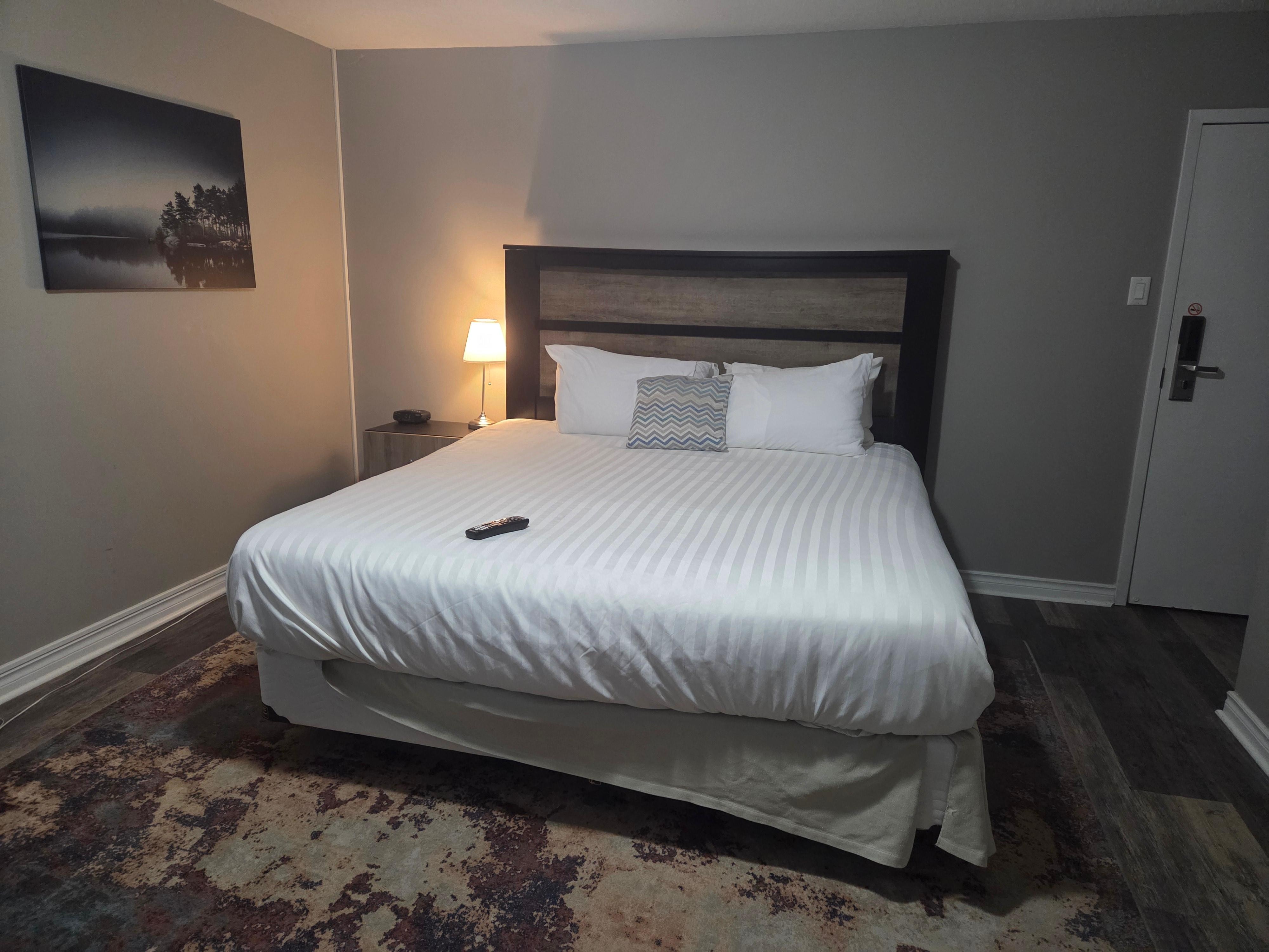 Night table on one side of King bed. Other table had TV with exposed cables.