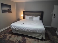 Night table on one side of King bed. Other table had TV with exposed cables.