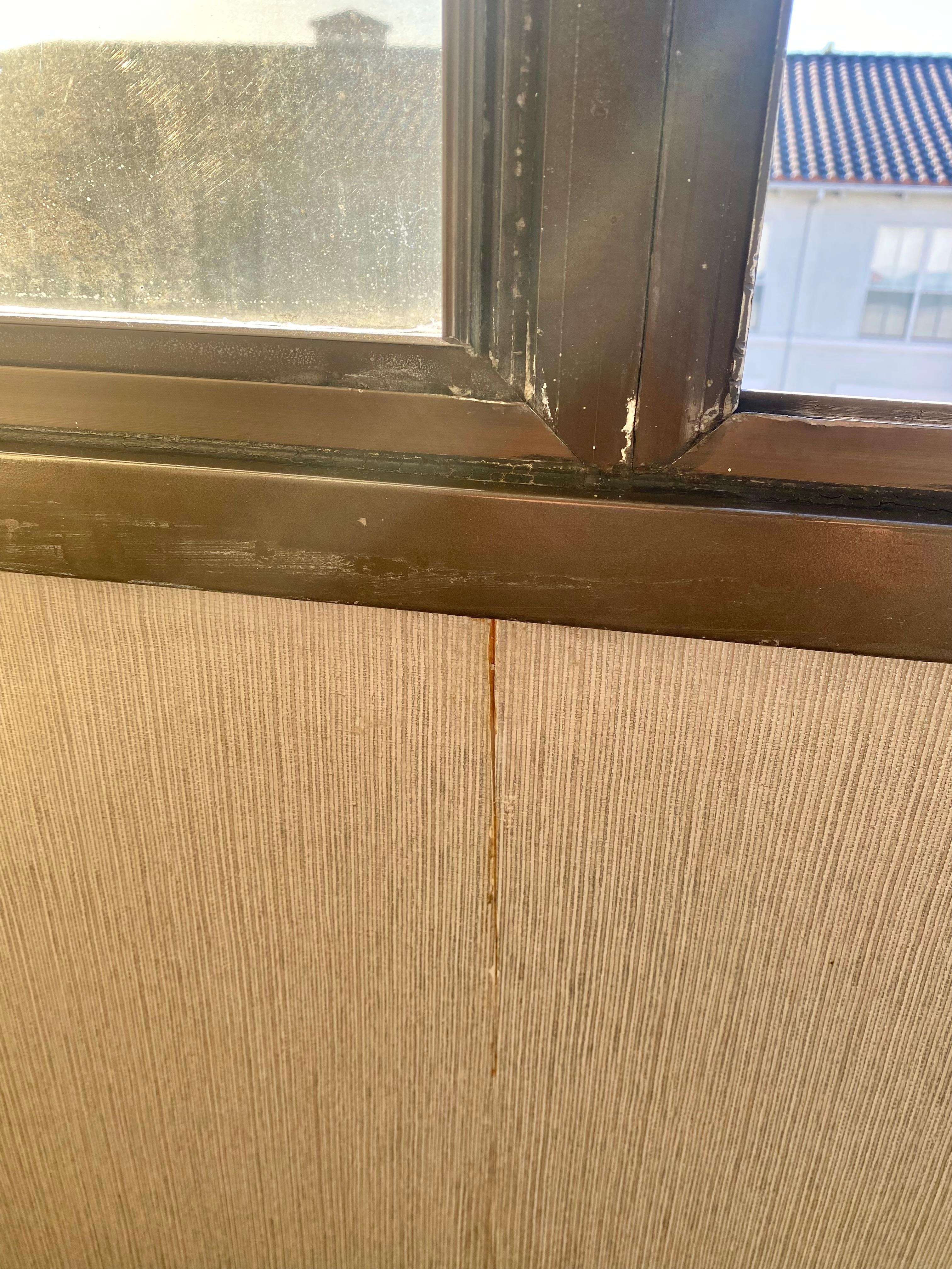 rusty window frames and peeling wallpaper